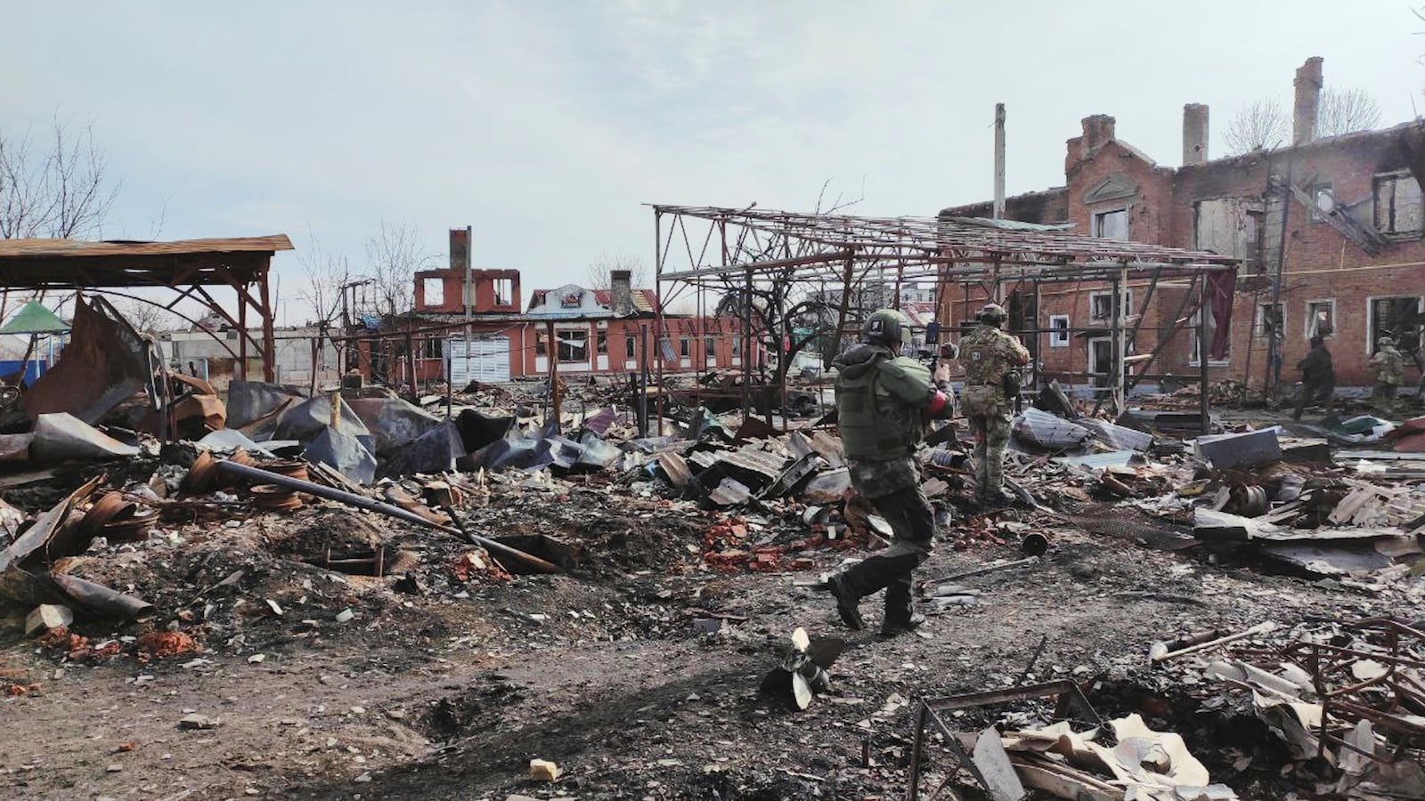 In this photo taken from video distributed by Russian Defense Ministry Press Service on Thursday, March 13, 2025, Russian soldiers walk between ruins of Sudzha, the biggest town in the Kursk region of Russia after it was taken over by Russian troops. (Russian Defense Ministry Press Service via AP)