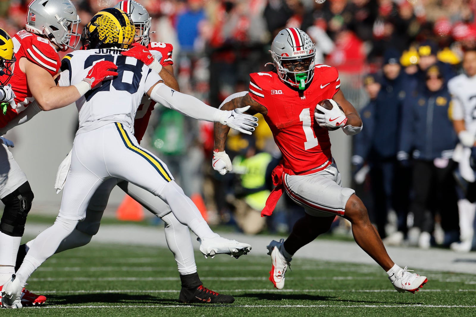 Ohio State running back Quinshon Judkins, right, cuts up field past Michigan defensive back Quinten Johnson during the first half of an NCAA college football game Saturday, Nov. 30, 2024, in Columbus, Ohio. (AP Photo/Jay LaPrete)