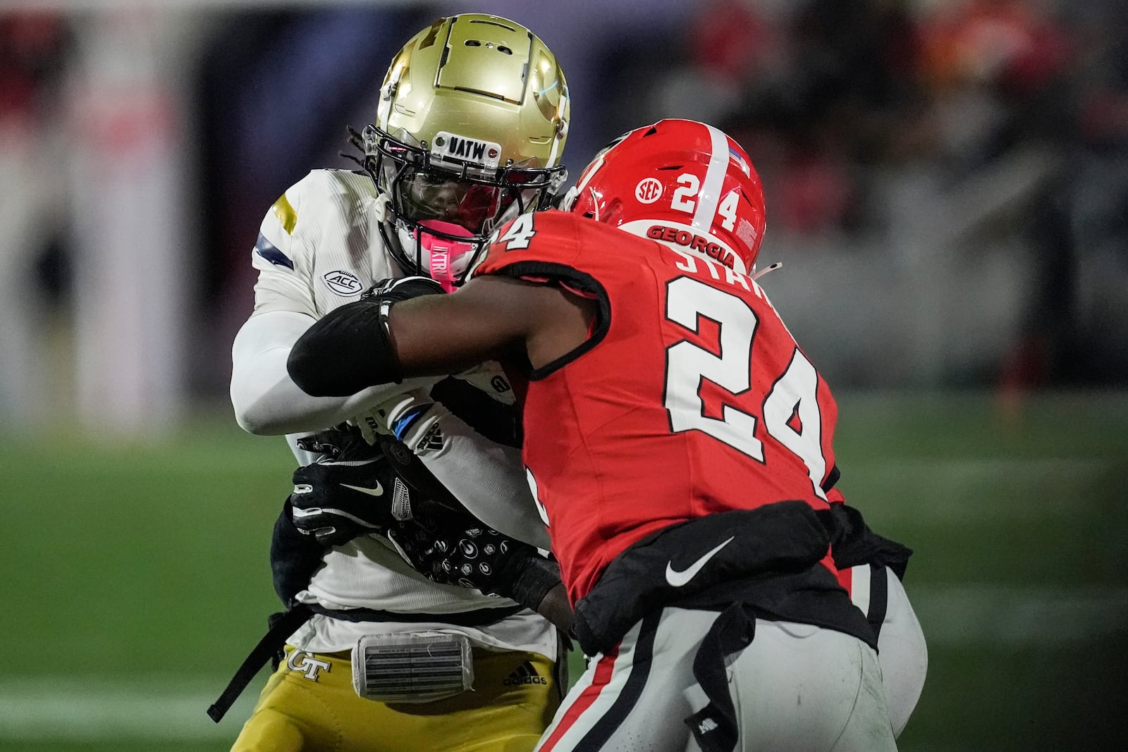 Georgia Tech wide receiver Eric Singleton Jr. (2) runs into Georgia defensive back Malaki Starks (24) during the first half of an NCAA college football game, Friday, Nov. 29, 2024, in Athens, Ga. (AP Photo/Mike Stewart)