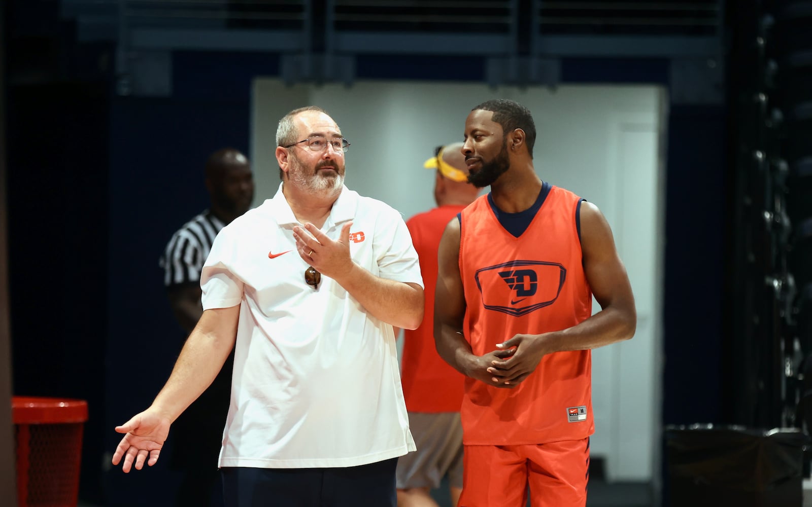 UD's Doug Hauschild, left, talks to former Flyer Scoochie. Smith before the Red Scare's scrimmage against We Are D3 on Thursday, July 18, 2024, at UD Arena two days before the start of The Basketball Tournament. David Jablonski/Staff