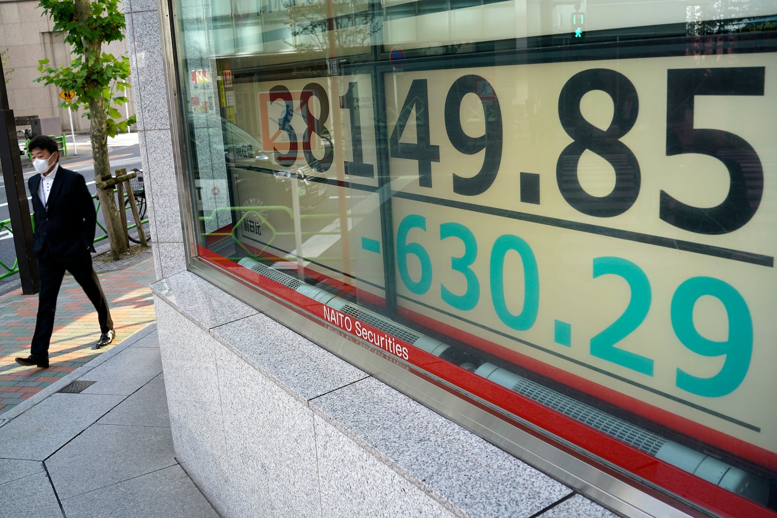 A person walks in front of an electronic stock board showing Japan's Nikkei index at a securities firm Tuesday, Nov. 26, 2024, in Tokyo. (AP Photo/Eugene Hoshiko)