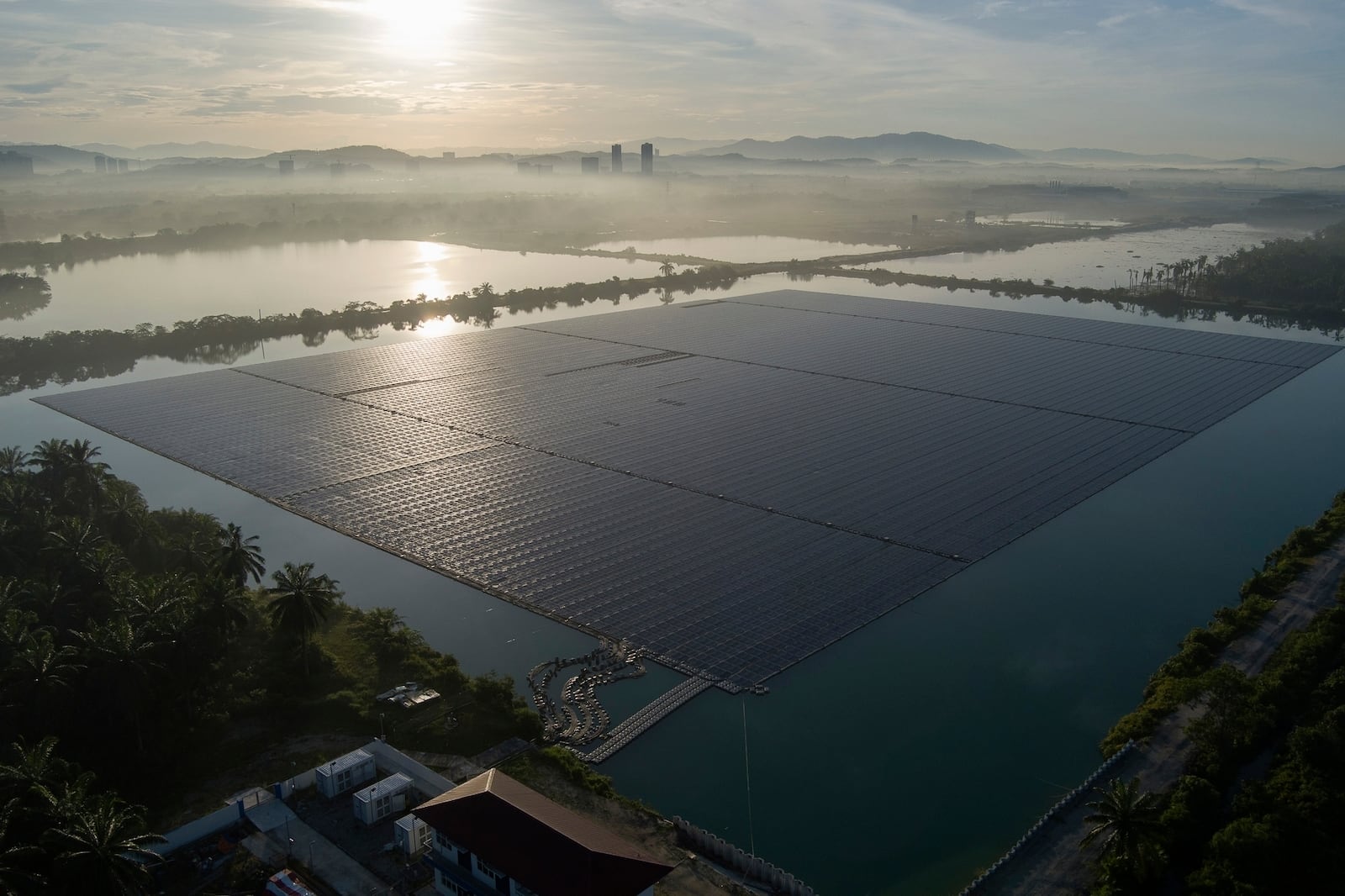 FILE- The sun rises over floating solar panels on May 3, 2023, in Selangor, Malaysia. (AP Photo/Vincent Thian, File)