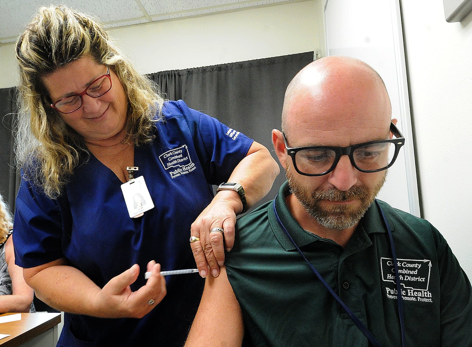 Clark County Combined Health District employee Nate Smith, received his updated Covid-19 vaccine, Thursday, July 20, 2023 from RN, Jo Windon. MARSHALL GORBY\STAFF