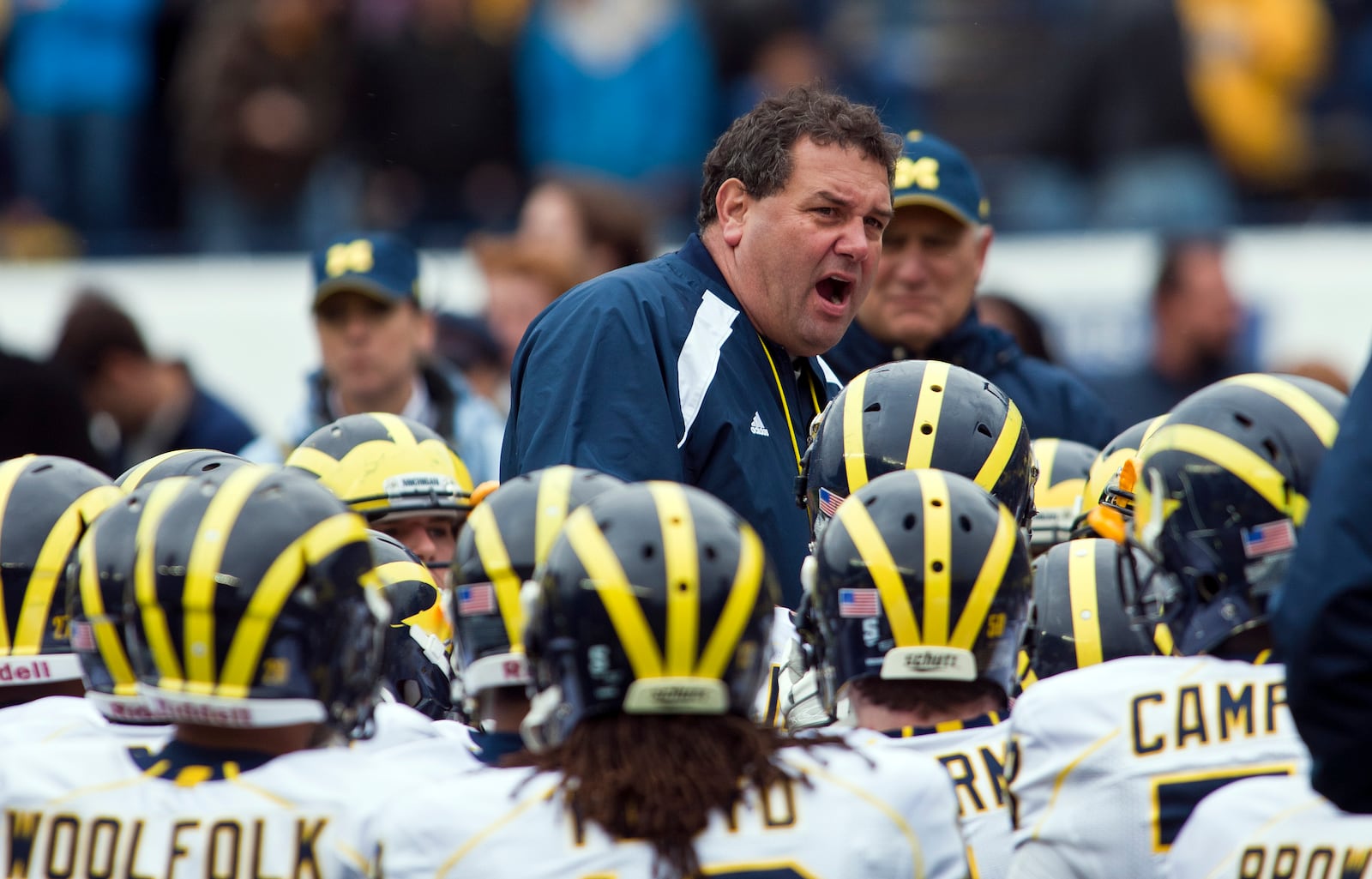 In this April 16, 2011 file photo, Michigan head coach Brady Hoke, center, speaks to his team after their spring NCAA college football game at Michigan Stadium in Ann Arbor, Mich. Michigan hired a husky coach with a raspy voice, hoping Ohio native Brady Hoke, who grew up rooting for the Wolverines, can restore college football's winningest program to glory after losses on and off the field led to Rich Rodriguez's ouster after just three seasons.  (AP Photo/Tony Ding, File)