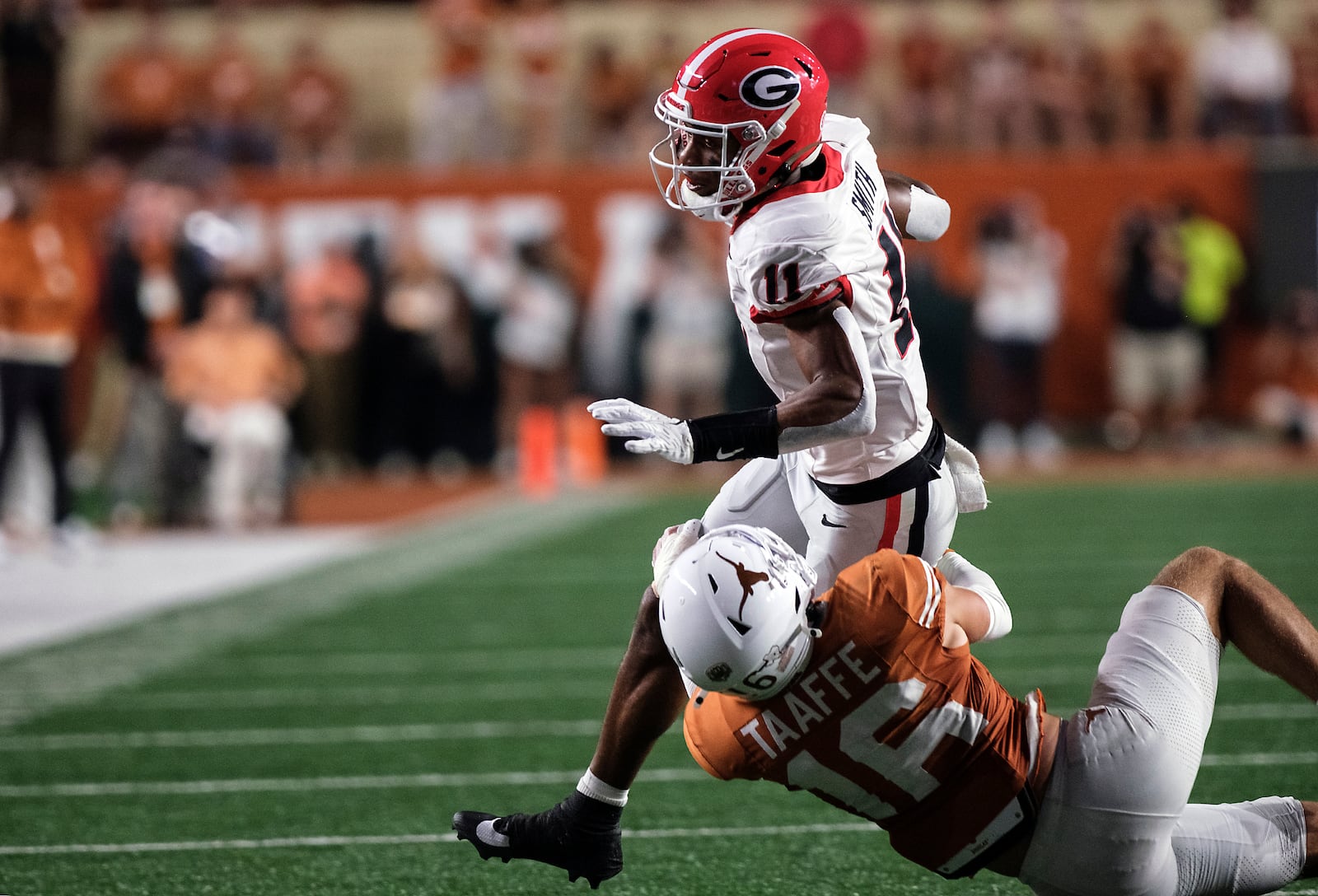 Georgia wide receiver Arian Smith (11) is tackled by Texas defensive back Michael Taaffe (16) during the first half of an NCAA college football game in Austin, Texas, Saturday, Oct. 19, 2024. (AP Photo/Rodolfo Gonzalez)