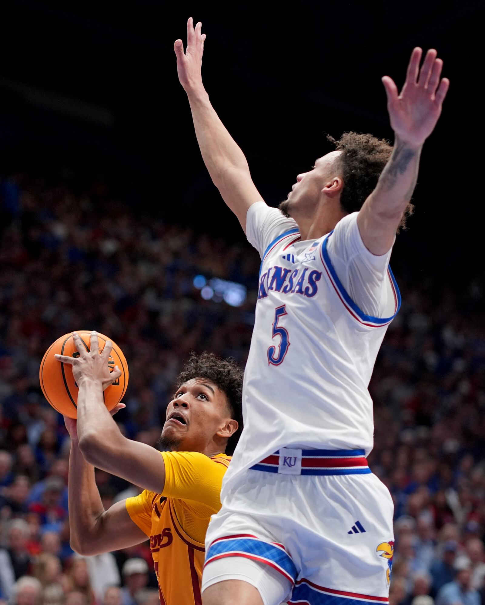 Iowa State guard Curtis Jones, left, looks to shoot under pressure from Kansas guard Zeke Mayo (5) during the second half of an NCAA college basketball game, Monday, Feb. 3, 2025, in Lawrence, Kan. (AP Photo/Charlie Riedel)