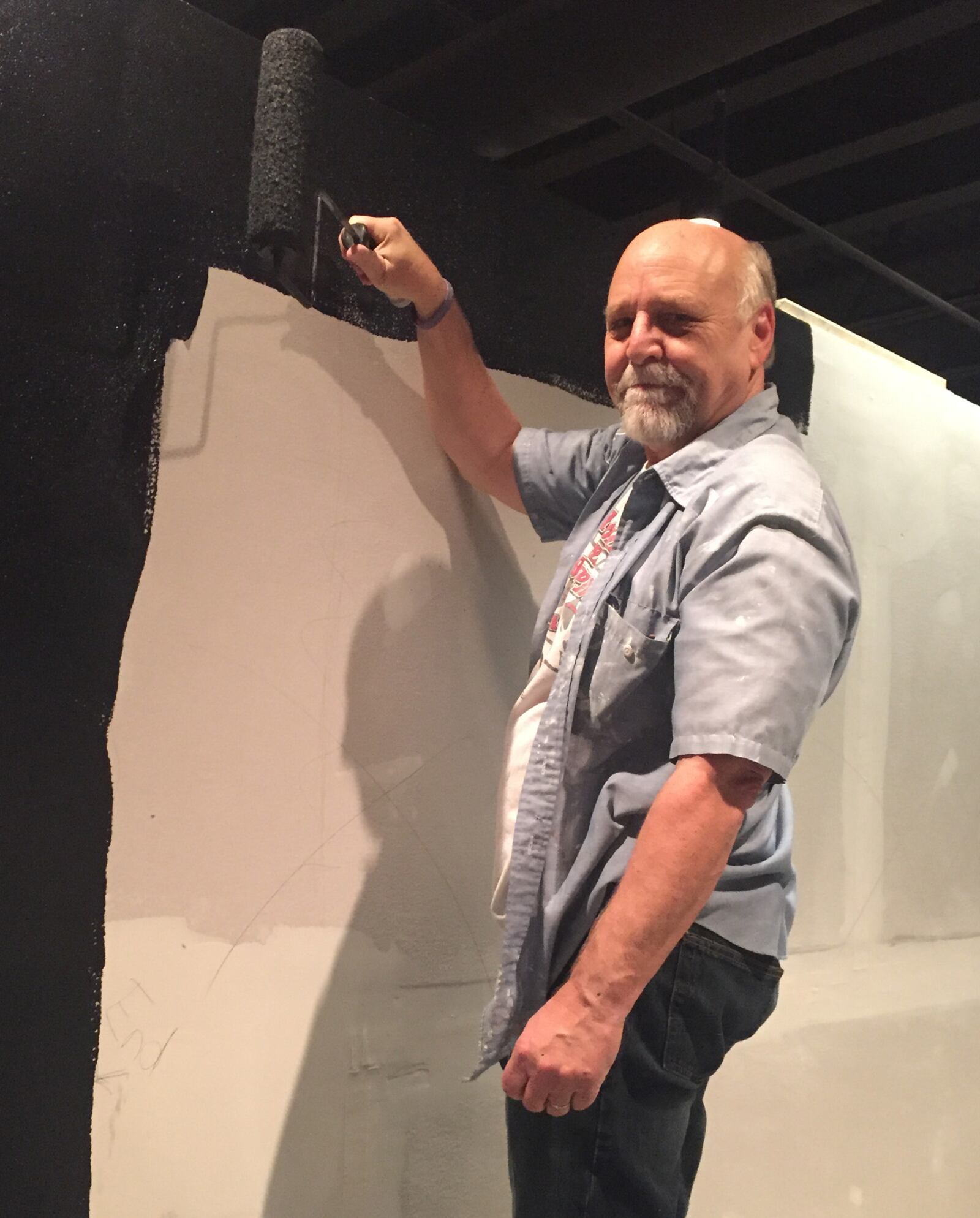 Retired Dayton police officer Steve Grismer installs a wall for the exhibit. Contributed 