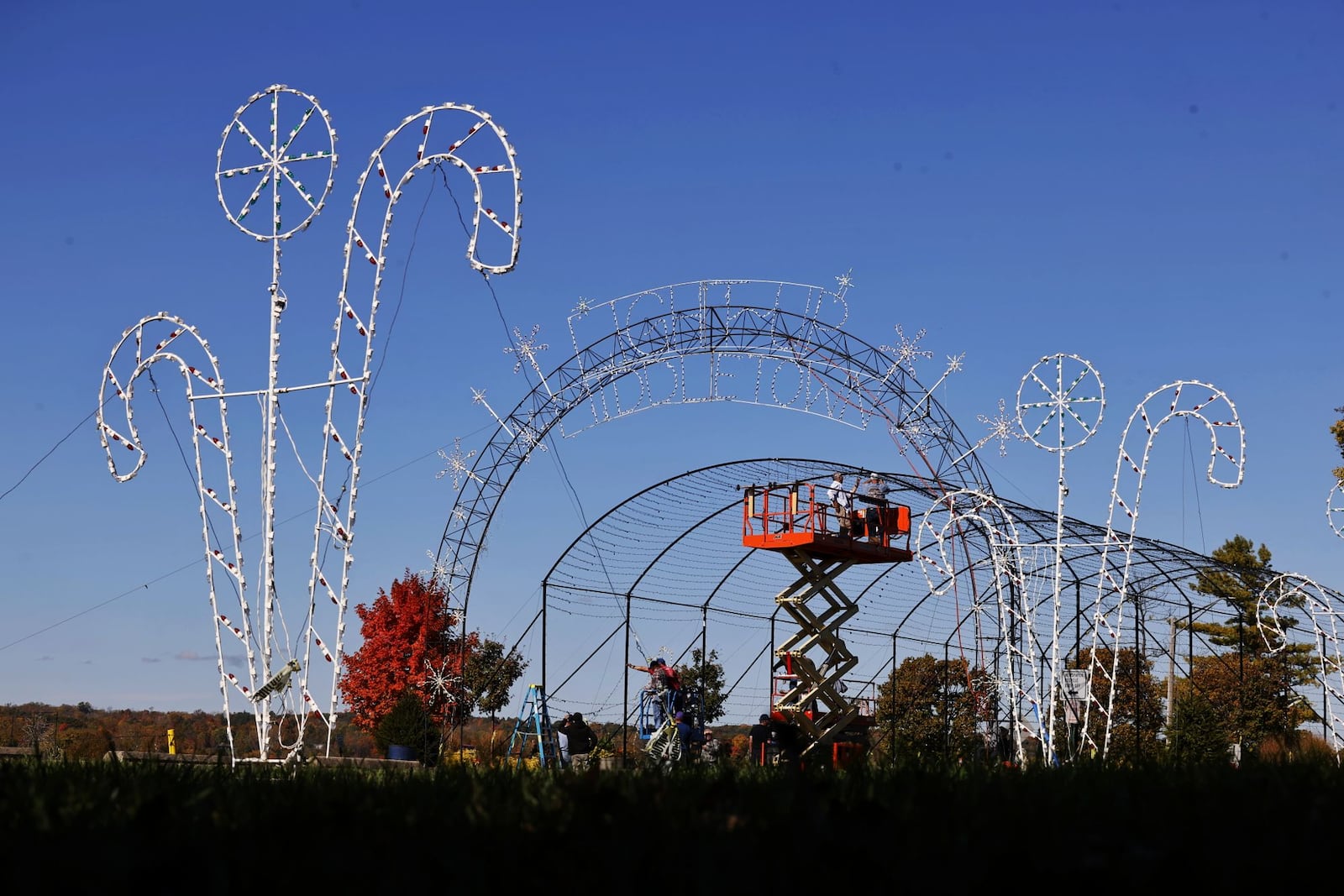 A group of volunteers known as The Grandpa Gang, install lights on the arch entrance Thursday, Oct. 24, 2024 for Light Up Middletown at Smith Park. NICK GRAHAM/STAFF