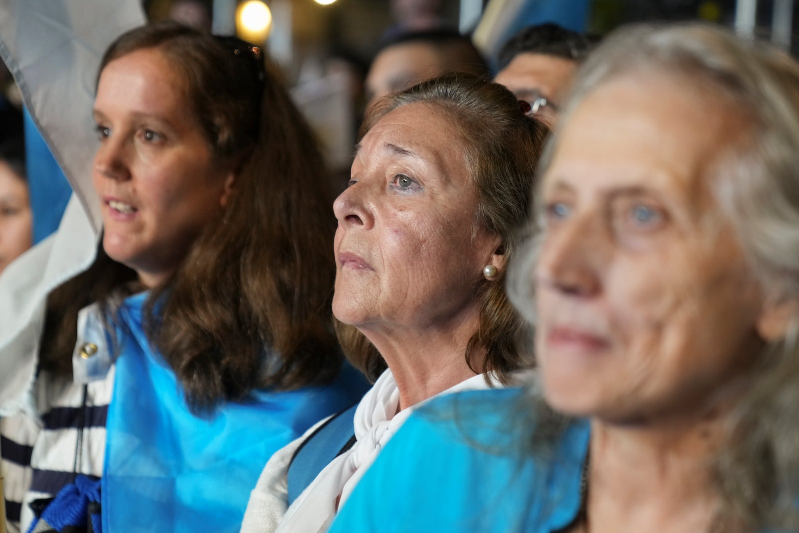 Supporters of Alvaro Delgado, presidential candidate for the ruling National Party, listen to early results from pollsters at the party's campaign night headquarters in Montevideo, Uruguay, after polls closed in the presidential run-off election, Sunday, Nov. 24, 2024. (AP Photo/Matilde Campodonico)