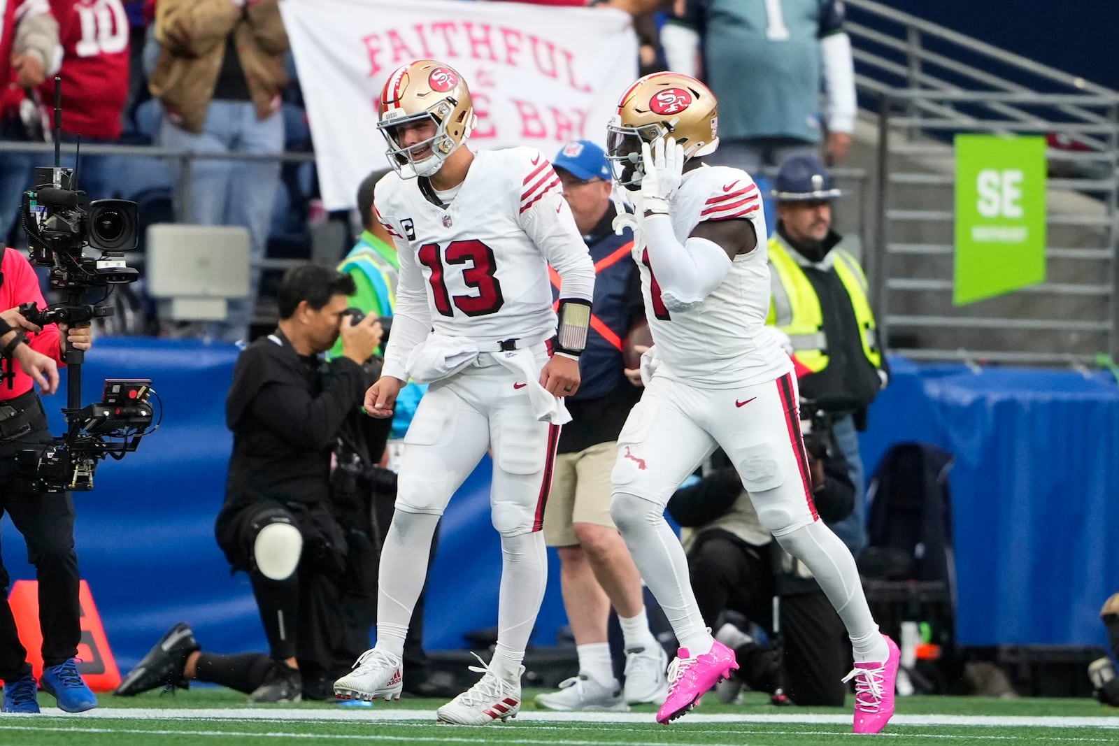 San Francisco 49ers quarterback Brock Purdy (13) ND Deebo Samuel Sr. (1) celebrate a touchdown by Samuel Sr. during the first half of an NFL football game against the Seattle Seahawkse, Thursday, Oct. 10, 2024, in Seattle. (AP Photo/Lindsey Wasson)