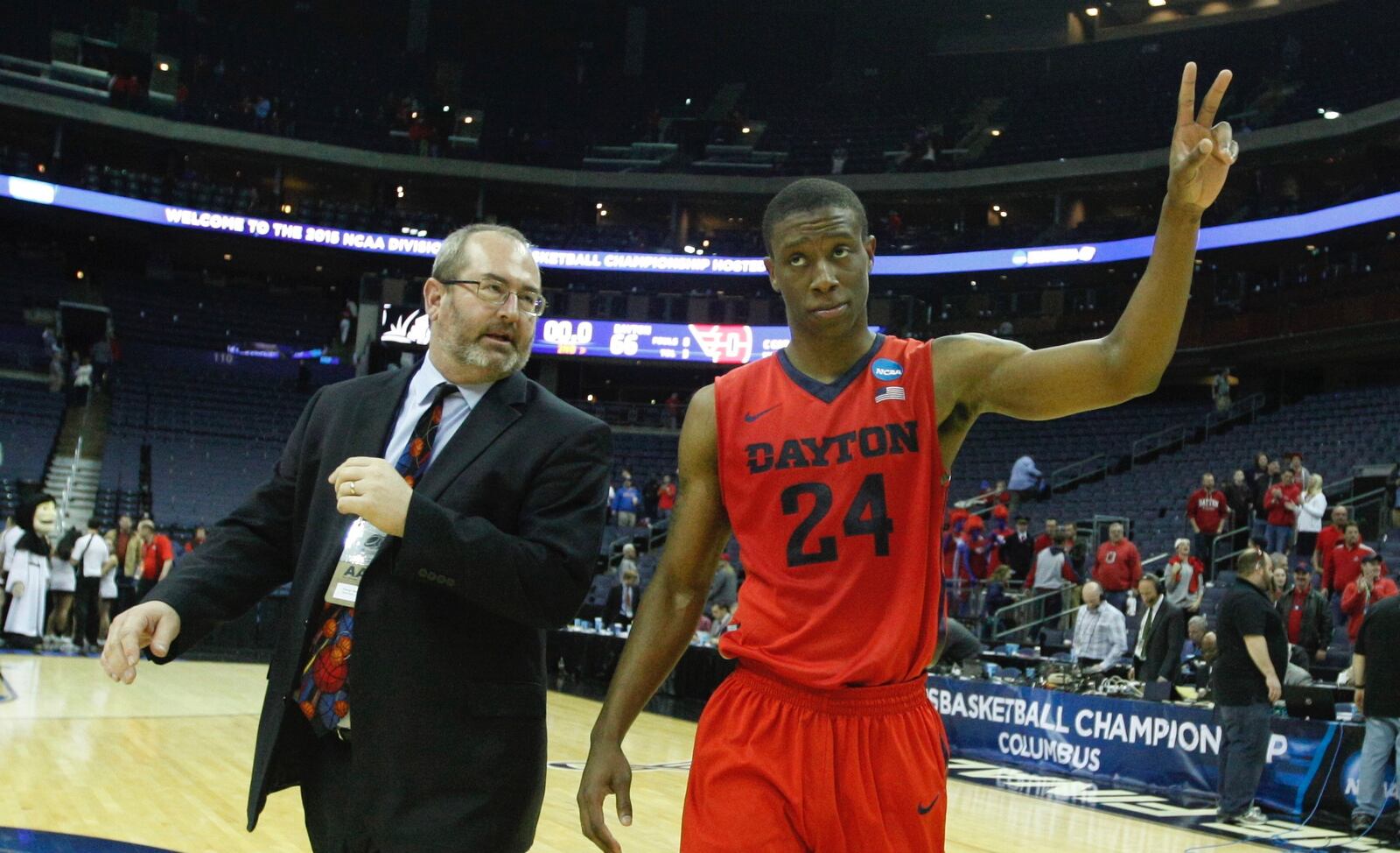 Dayton's Jordan Sibert, right, and Doug Hauschild, UD's director of media relations, leave the court after a victory against Providence in the second round of the NCAA tournament on Friday, March 20, 2015, at Nationwide Arena in Columbus. David Jablonski/Staff