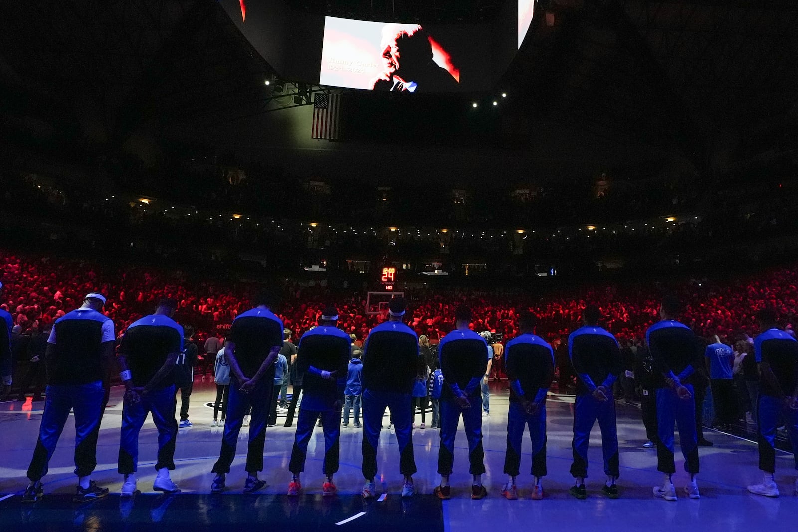 Dallas Mavericks players line up for a moment of silence honoring former President Jimmy Carter prior to an NBA basketball game against the Cleveland Cavaliers, Friday, Jan. 3, 2025, in Dallas. (AP Photo/Julio Cortez)