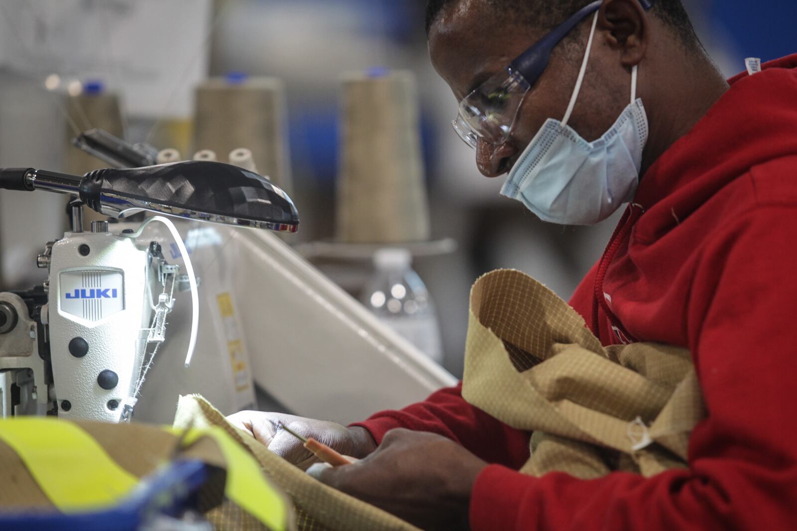 Amisi Pelo works on a damage control navy suit at Lion Inc. in Dayton. JIM NOELKER/STAFF