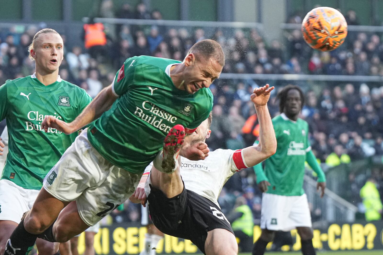 Plymouth Argyle's Nikola Katic, left, clears the ball next to Liverpool's Diogo Jota during the English FA Cup fourth round soccer match between Plymouth Argyle and Liverpool at Home Park stadium in Plymouth, England, Sunday, Feb. 9, 2025. (AP Photo/Alastair Grant)