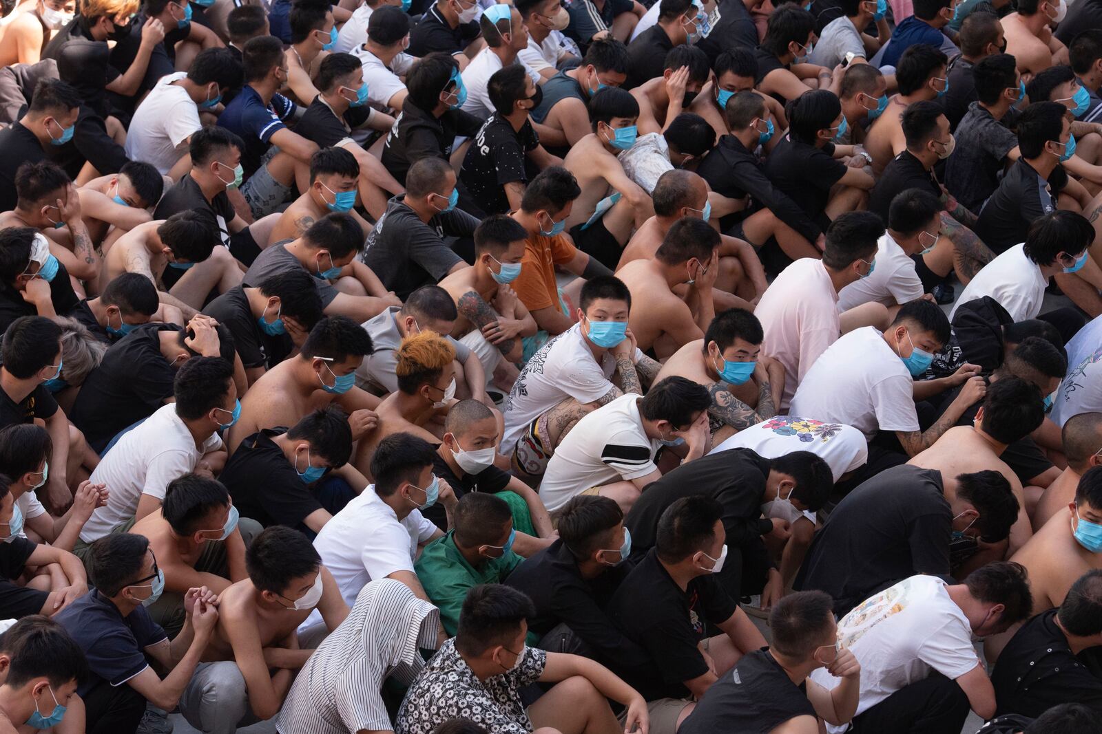 People from China, Vietnam and Ethiopia, believed to have been trafficked and forced to work in scam centers, sit with their faces masked while in detention after being released from the centers in Myawaddy district in eastern Myanmar, Wednesday, Feb. 26, 2025. (AP Photo/Thanaphon Wuttison)