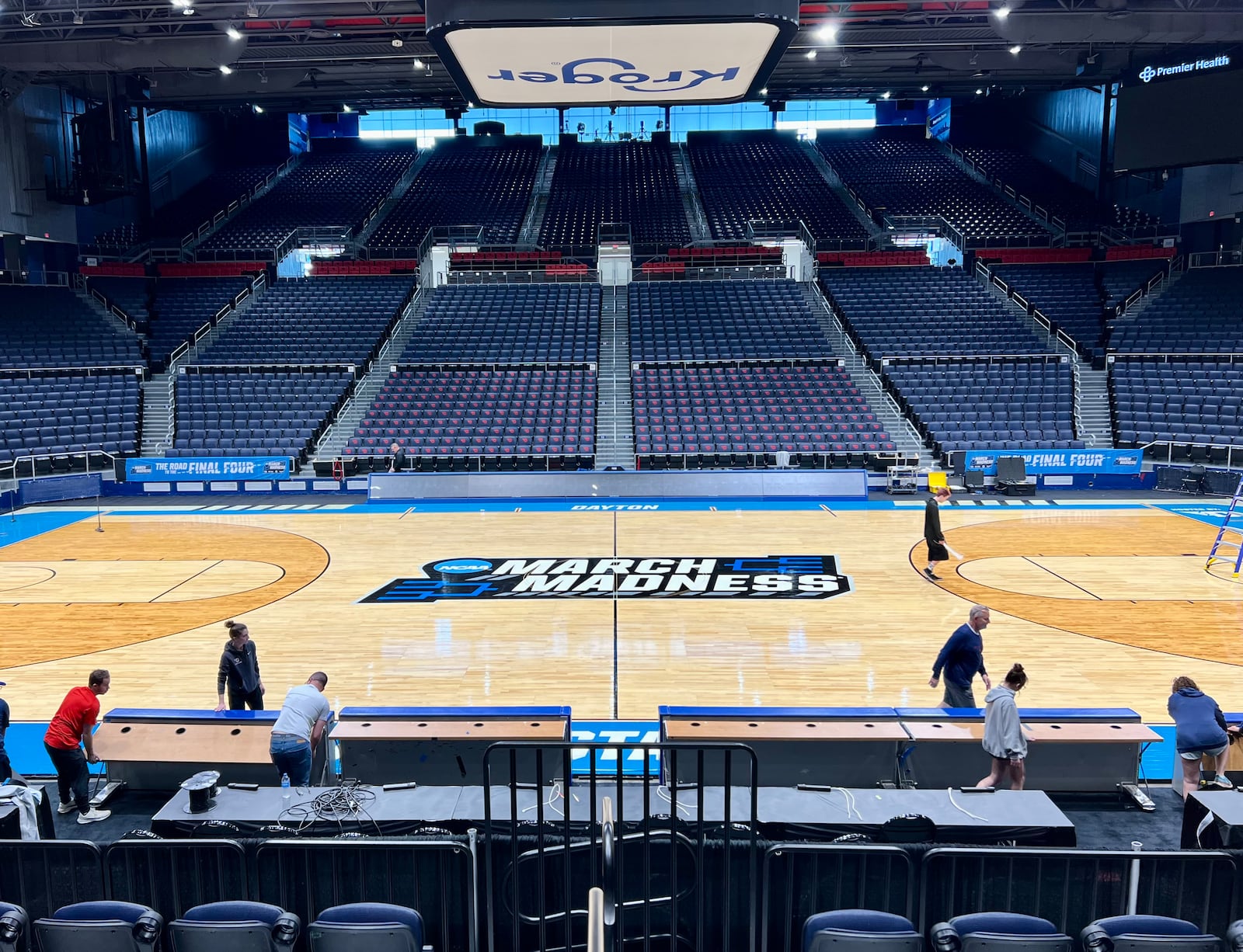 Workers on Sunday put the finishing touches on the basketball court installation for the First Four of the NCAA Division I Men’s Basketball Championship at UD Arena. AIMEE HANCOCK/STAFF