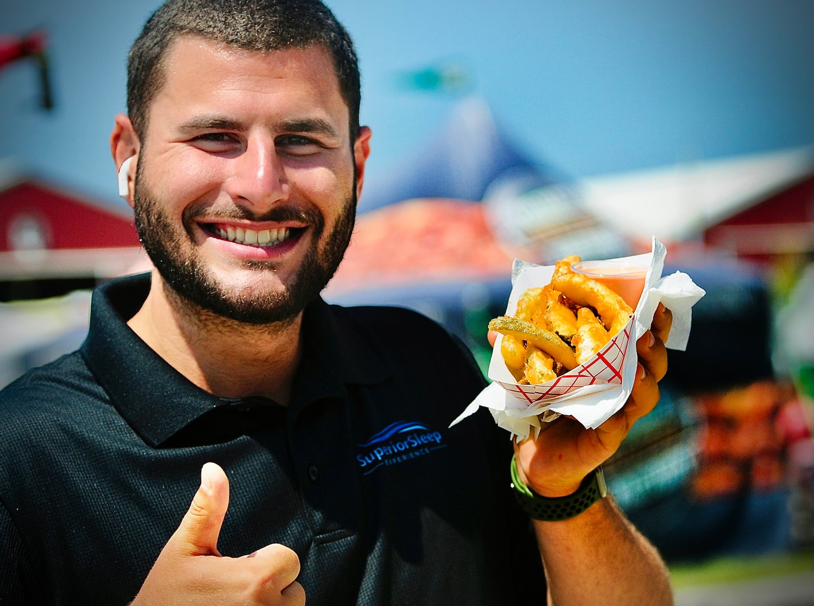 John Stumberger, of New York gives a big thumbs up Thursday, July 11, 2024 to the deep fried pickles at the Montgomery County Fair. MARSHALL GORBY\STAFF