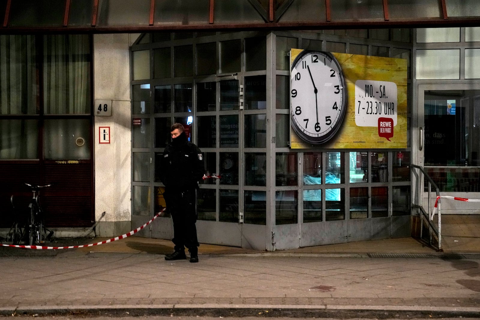 A Police officer stands guard in front of a Rewe Market after a knife attack, in Berlin, Germany, Tuesday, Dec. 31, 2024. (AP Photo/Ebrahim Noroozi)