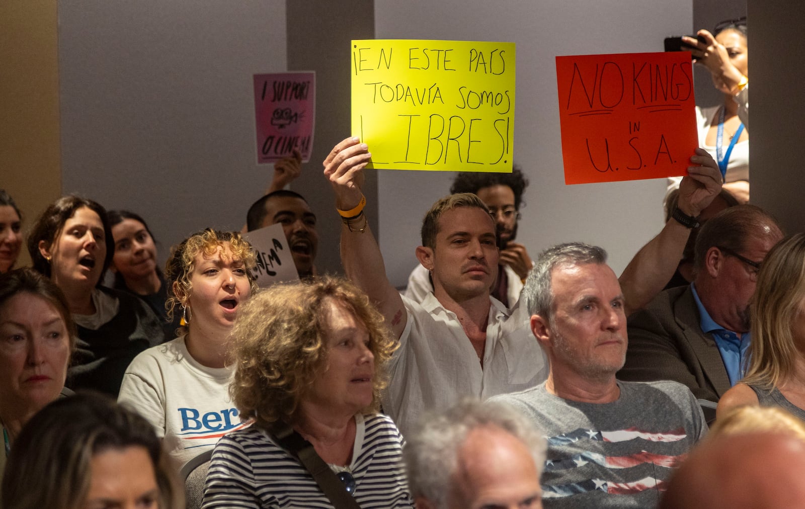 Miami Beach resident Phillip Carter holds up protest signs sign during the public speaking portion as the City Commission was expected to discuss Mayor Steven Meiner's proposal to terminate a lease and cut financial support for the independent film theater on Wednesday, March 19, 2025 in Miami Beach, Fla. (Jose Iglesias /Miami Herald via AP)