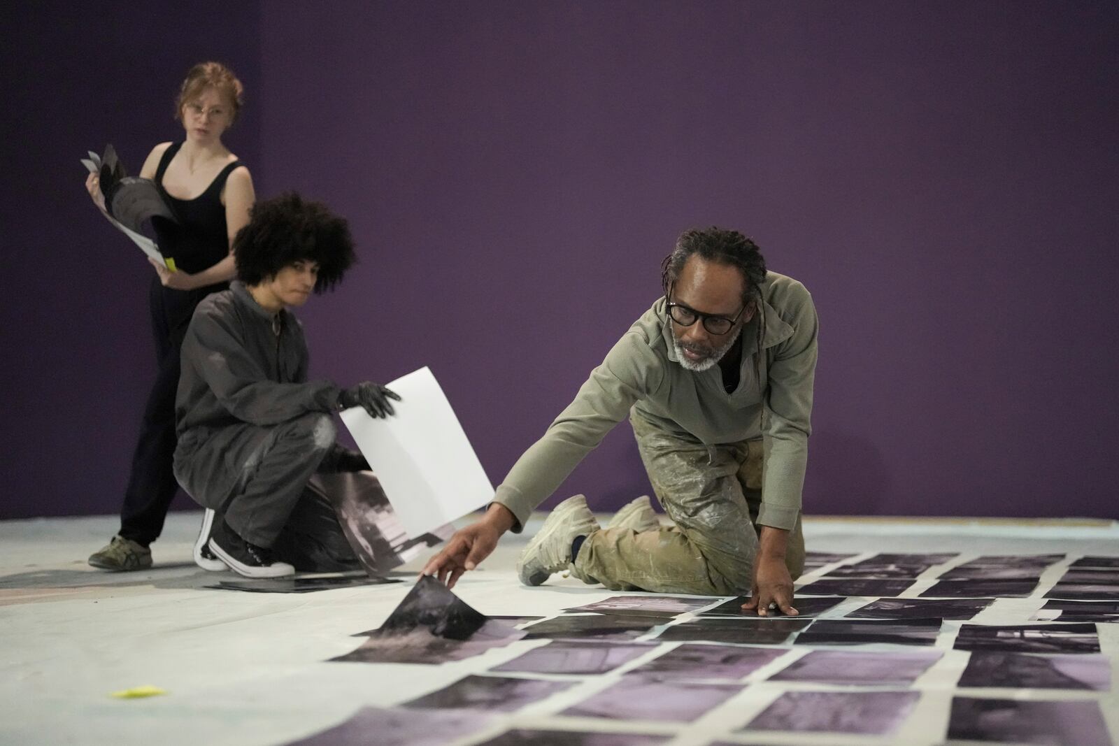 Assistants of French artist Shuck One displays archive images during the preparation of the exhibition "Paris Noir", at the Centre Pompidou Museum, in Paris, Tuesday, Feb. 18, 2025. (AP Photo/Thibault Camus)