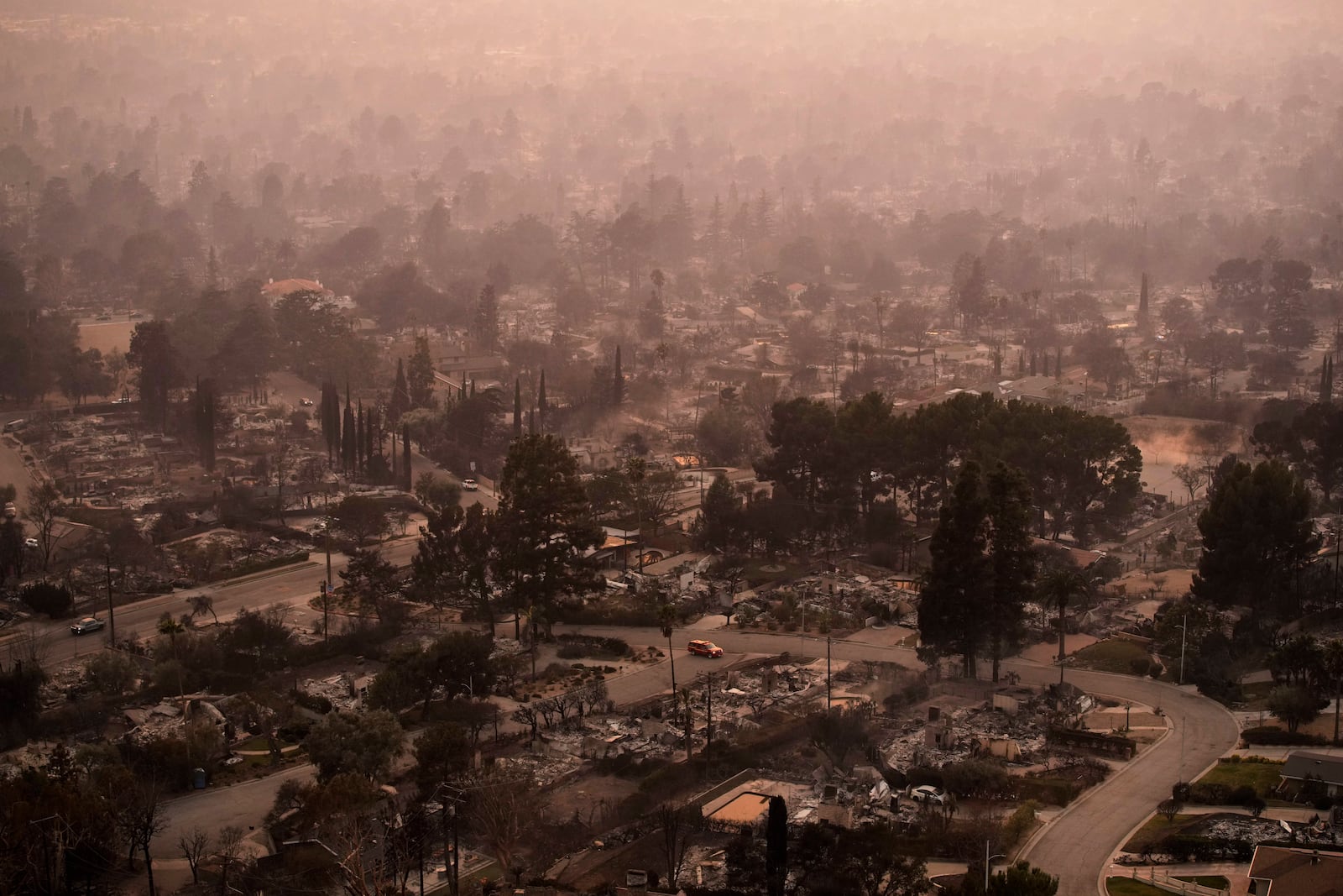 FILE - Smoke lingers over a neighborhood devastated by the Eaton Fire, Jan. 9, 2025, in Altadena, Calif. (AP Photo/John Locher, File)