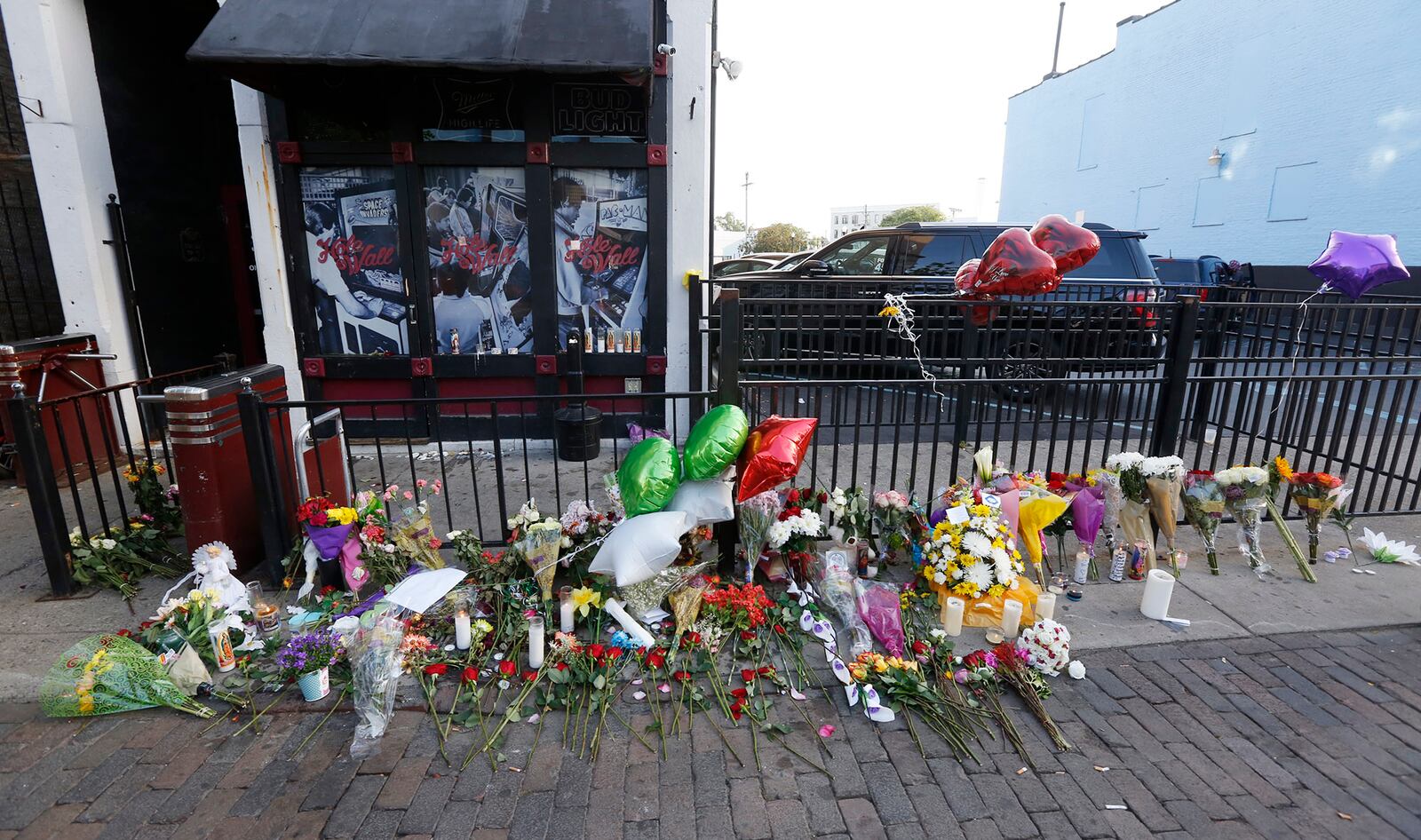 A memorial on the sidewalk of East Fifth Street in Dayton, seen here on Tuesday, has grown since the mass shooting early Sunday morning.  TY GREENLEES / STAFF