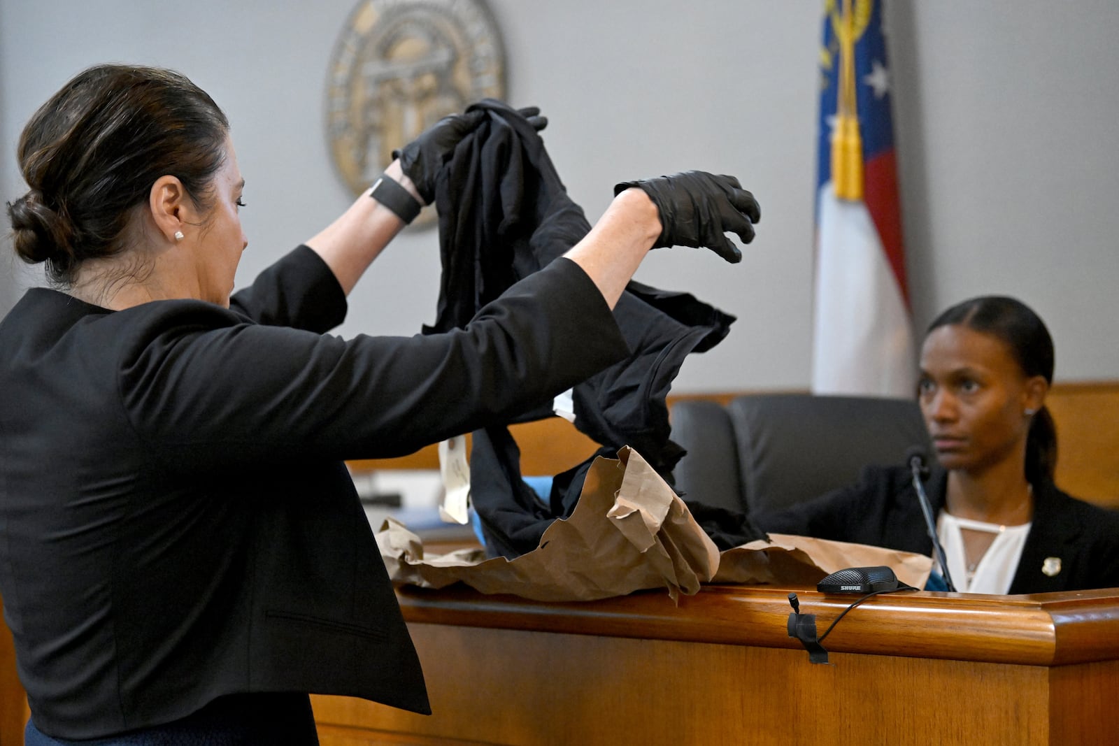 Prosecutor Sheila Ross holds clothings Laken Riley worn as GBI Crime Scene Specialist Daniella Stuart, right, testifies on the witness stand during the trial of Jose Ibarra, accused of killing a Georgia nursing student earlier this year, at Athens-Clarke County Superior Court, Friday, Nov. 15, 2024, in Athens. (Hyosub Shin/Atlanta Journal-Constitution via AP, Pool)