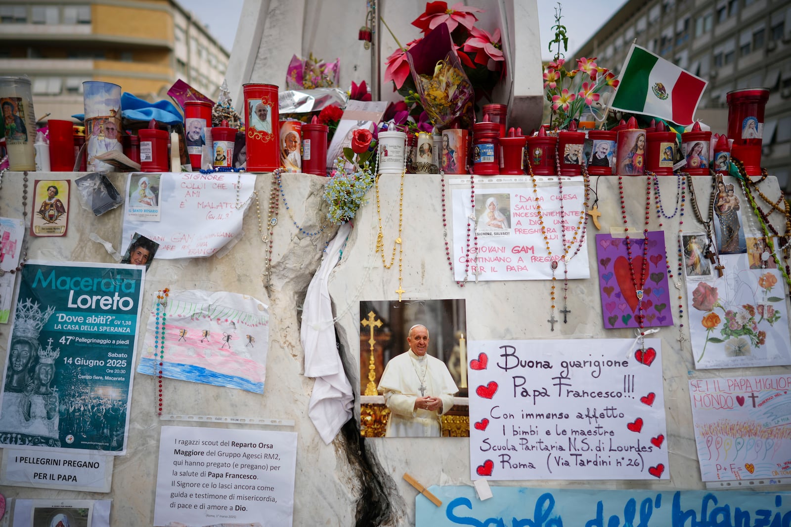 Candles and flowers are left for Pope Francis in front of the Agostino Gemelli Polyclinic, in Rome, Saturday, March 8, 2025, where the Pontiff is hospitalized since Feb. 14. (AP Photo/Andrew Medichini)