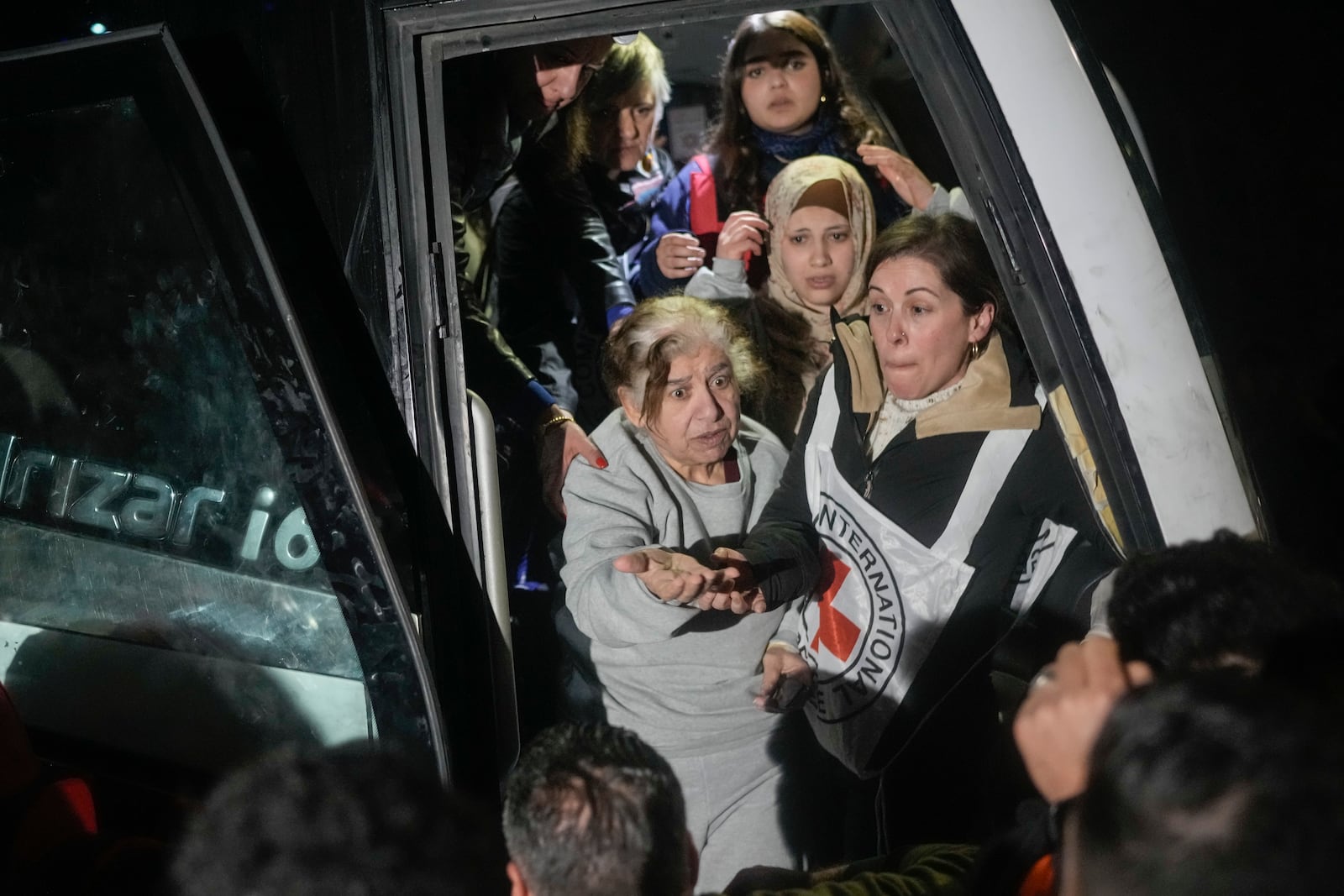 Female Palestinian prisoners disembark from a bus after being released from an Israeli prison, in the West Bank city of Beitunia, early Monday, Jan. 20, 2025. (AP Photo/Leo Correa)