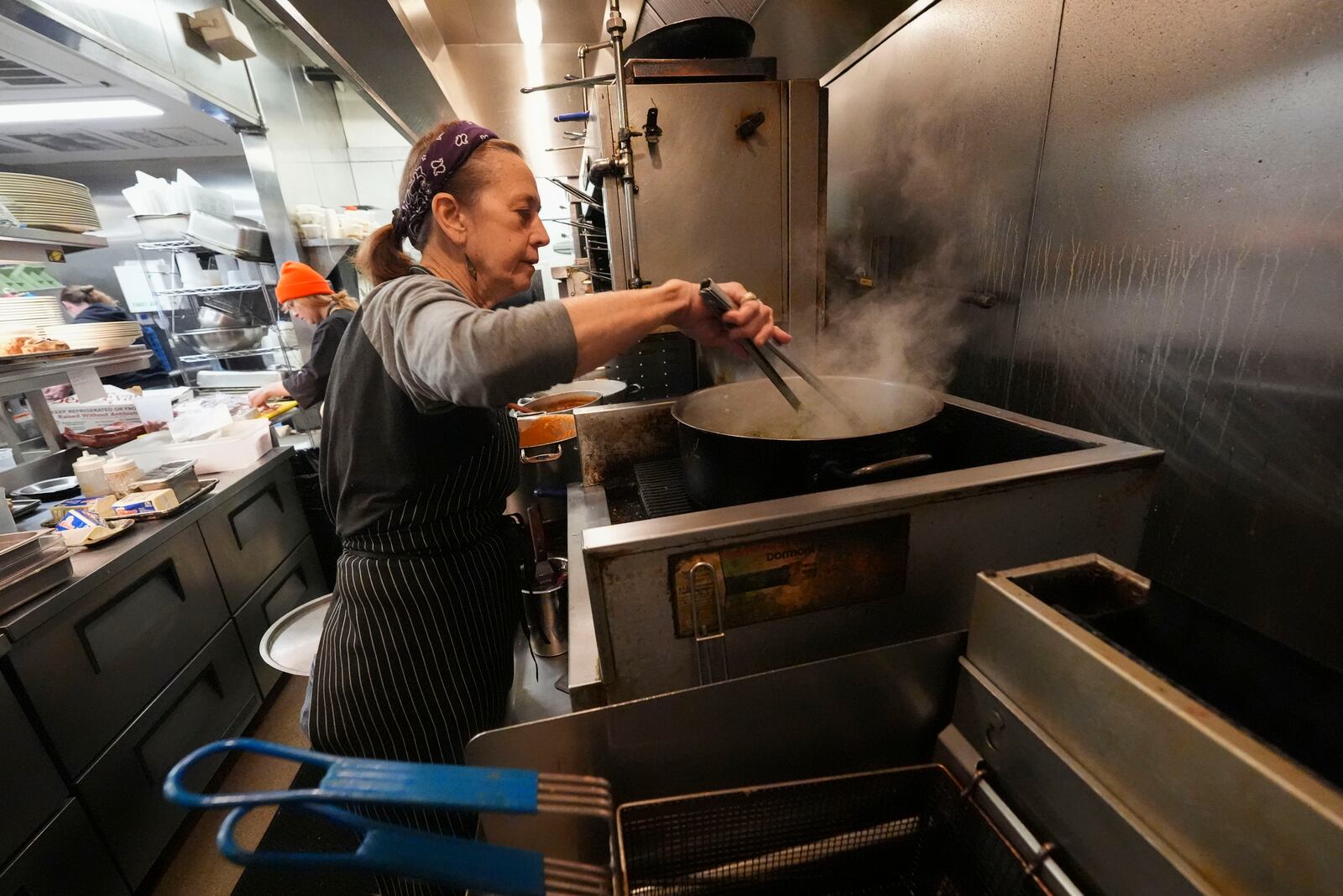 Celebrity chef Susan Spicer starts her morning cooking in her restaurant Rosedale in New Orleans, Friday, Jan. 24, 2025. (AP Photo/Gerald Herbert)