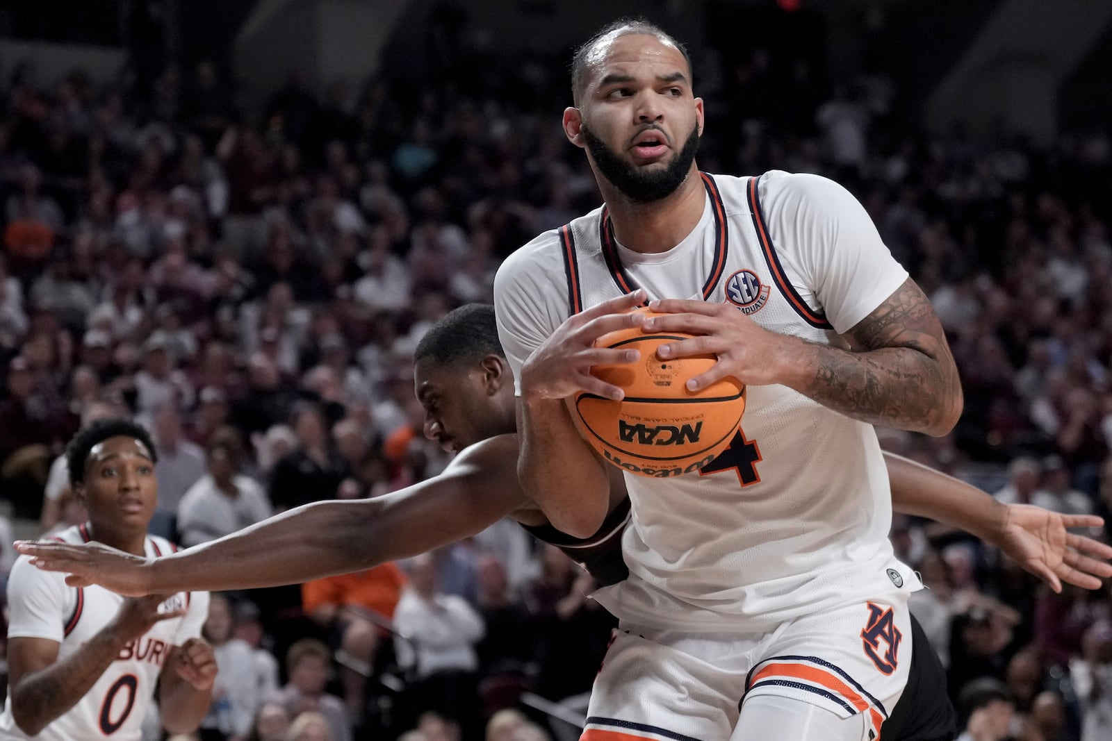 Auburn forward Johni Broome, front, grabs a rebound away from Texas A&M forward Henry Coleman III, back, during the first half of an NCAA college basketball game, Tuesday, March 4, 2025, in College Station, Texas. (AP Photo/Sam Craft)