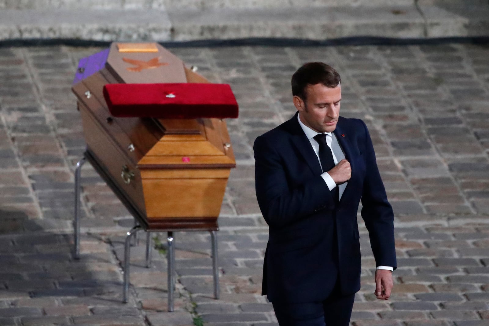 FILE - French President Emmanuel Macron leaves after paying his respects by the coffin of slain teacher Samuel Paty in the courtyard of the Sorbonne university during a national memorial event, Wednesday, Oct. 21, 2020 in Paris. (AP Photo/Francois Mori, Pool, File)