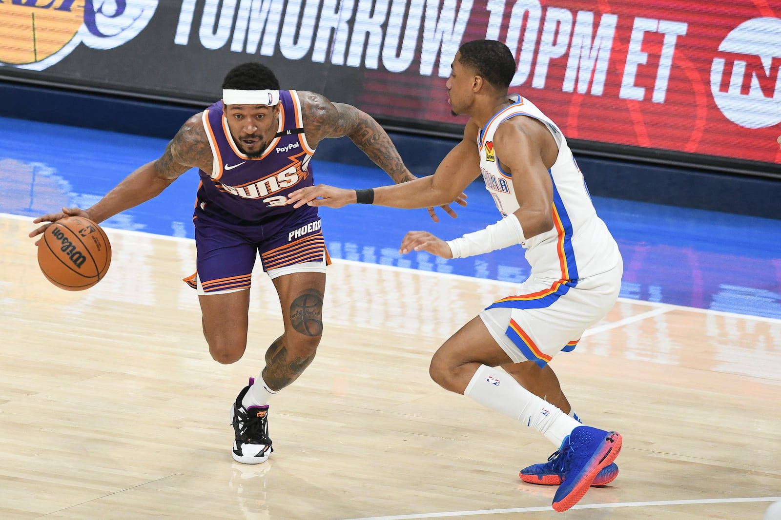 Phoenix Suns guard Bradley Beal, left, drives past Oklahoma City Thunder guard Aaron Wiggins, right, during the first half of an NBA basketball game, Wednesday, Feb. 5, 2025, in Oklahoma City. (AP Photo/Kyle Phillips)