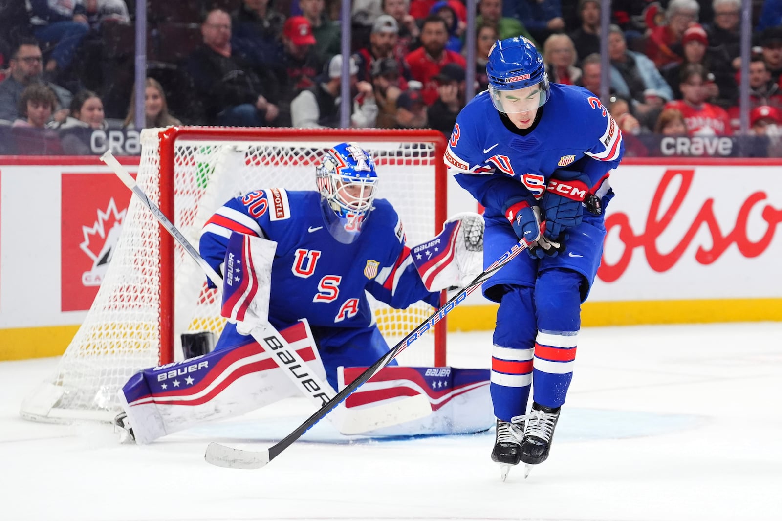 USA defenseman Logan Hensler (3) reacts as he blocks a shot with his body during second period of a quarterfinal match against Switzerland at the IIHF World Junior Hockey Championship in Ottawa, Ontario Thursday, Jan. 2, 2025. (Sean Kilpatrick/The Canadian Press via AP)