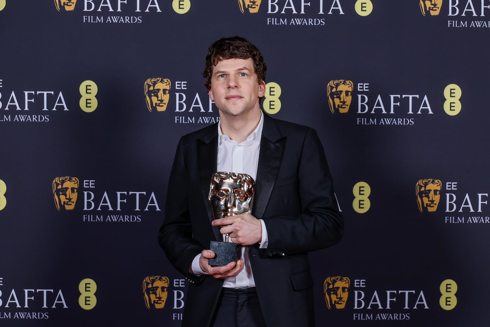 Jesse Eisenberg poses with the best supporting actor award he received on behalf of Kieran Culkin for "A Real Pain" at the 78th British Academy Film Awards, BAFTA's, in London, Sunday, Feb. 16, 2025. (Photo by Joel C Ryan/Invision/AP)