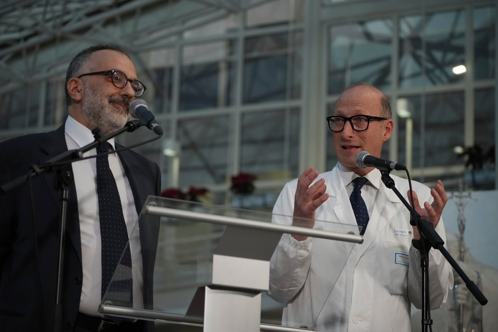 Surgeon Sergio Alfieri, right, and head physician of the Vatican's health and hygiene office, Luigi Carbone speak to journalists, Friday, Feb. 21, 2025, in the entrance hall of Rome's Agostino Gemelli Polyclinic where Pope Francis is being treated for pneumonia. (AP Photo/Alessandra Tarantino)