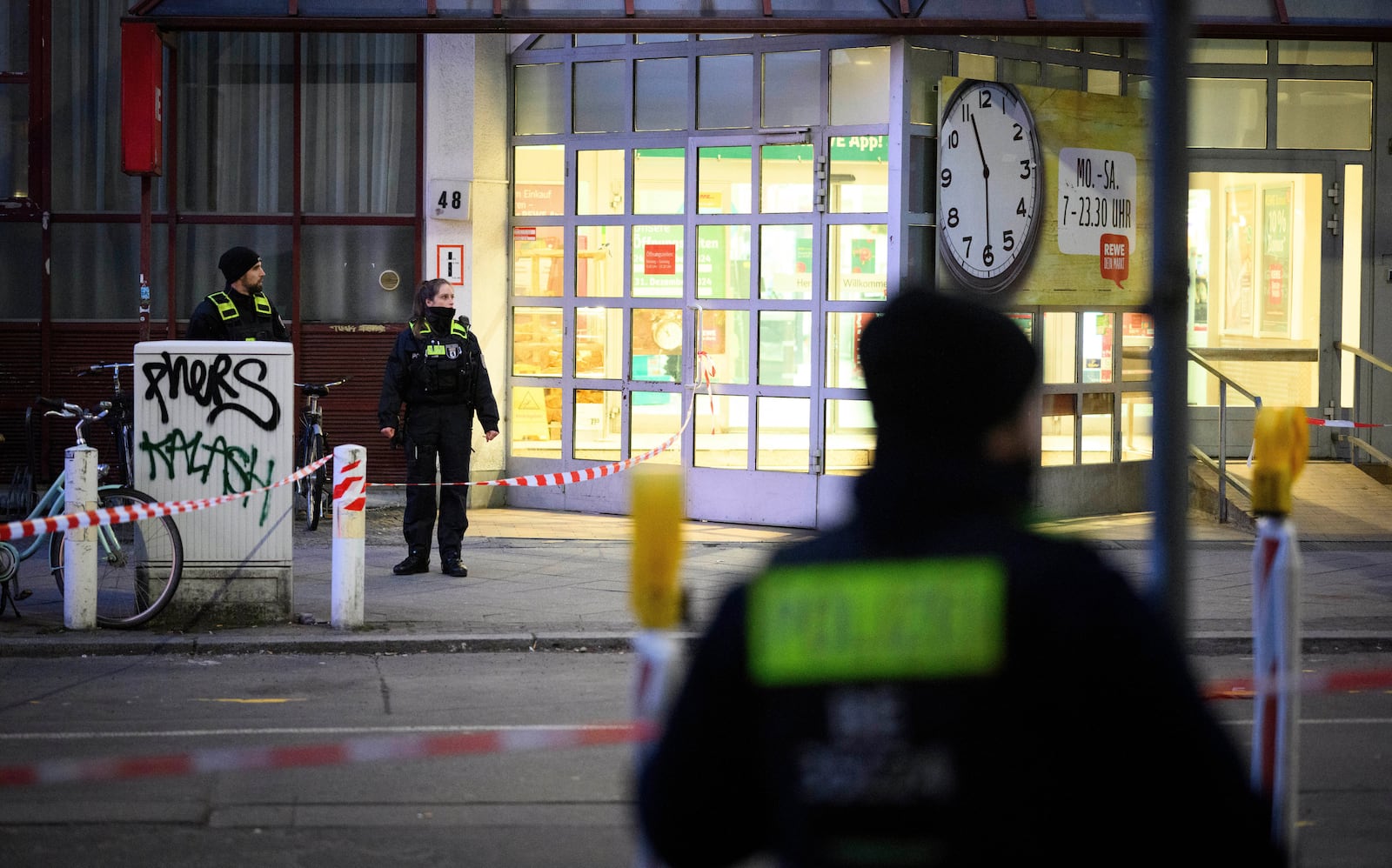 Police officers stand at a cordoned-off area in front of a supermarket in Berlin-Charlottenburg after an incident, in Berlin, Tuesday, Dec. 31, 2024. (Bernd von Jutrczenka/dpa via AP)