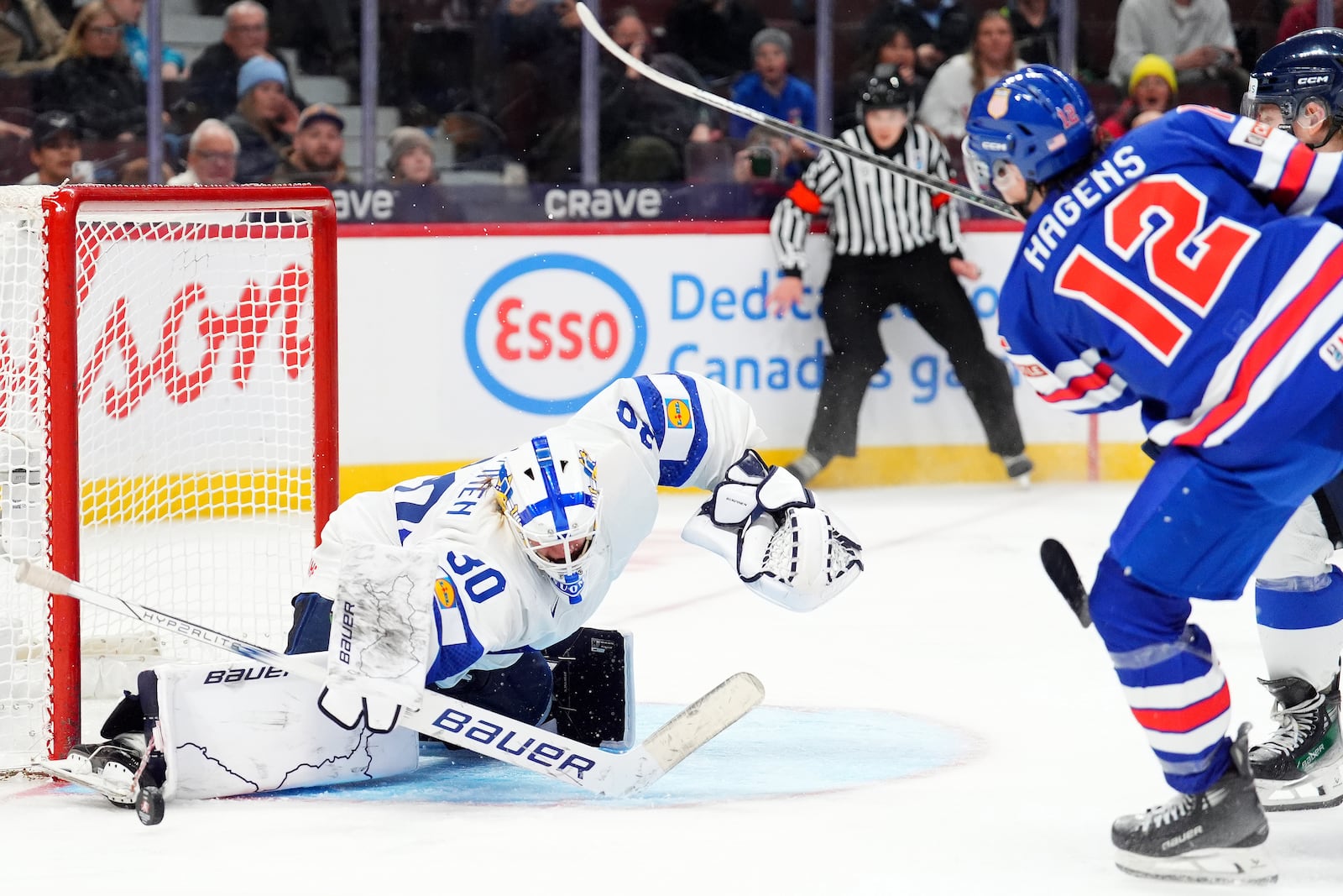 Finland goaltender Petteri Rimpinen (30) makes a save against United States forward James Hagens (12) during third-period IIHF World Junior Hockey Championship gold medal game action in Ottawa, Ontario, Sunday, Jan. 5, 2025. (Sean Kilpatrick/The Canadian Press via AP)