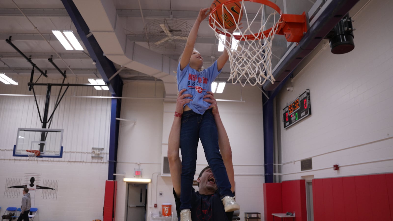 Dayton Flyers 6-foot-10 Issac Jack gives his alley-oop assist to Parker Roche for her dunk after the Flyers practice. CONTRIBUTED