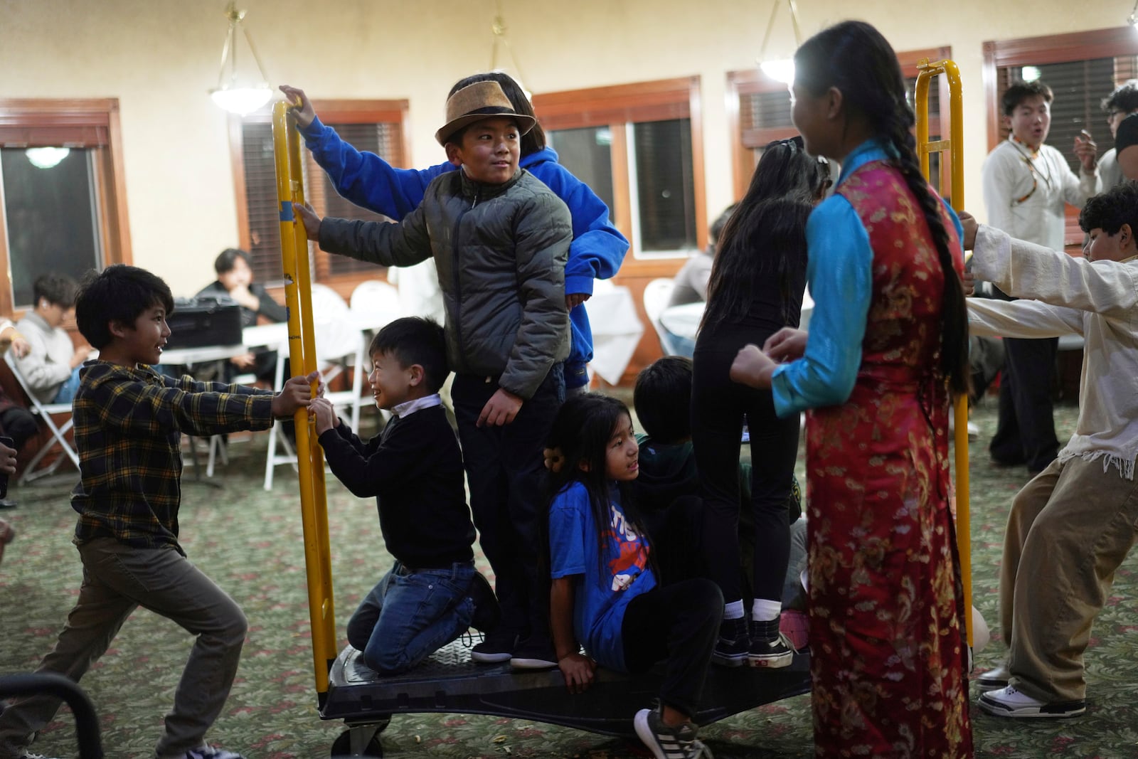 Kids play in a back room of the Tibetan American Foundation of Minnesota during the 18th birthday and enthronement ceremony for U.S.-born Buddhist lama, Jalue Dorje, in Isanti, Minn., on Saturday, Nov. 9, 2024. (AP Photo/Jessie Wardarski)