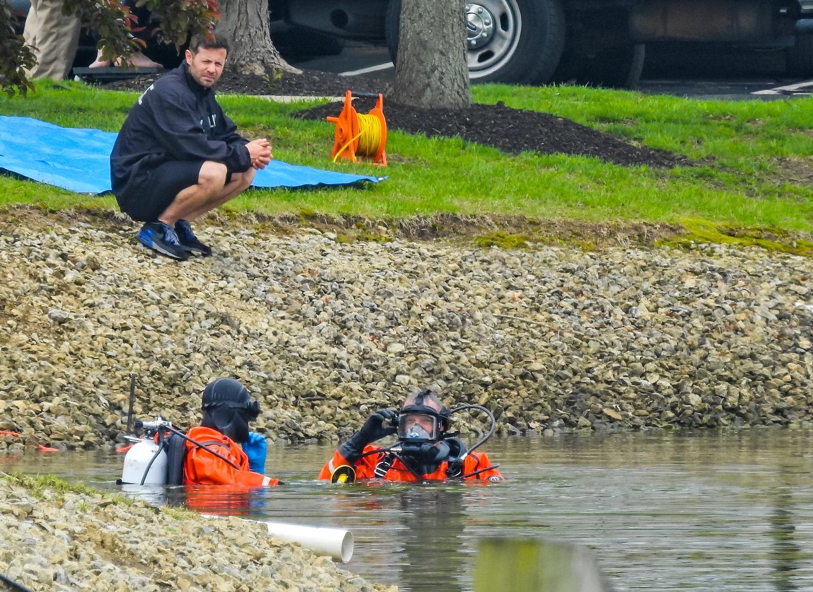 Ohio Bureau of Criminal Investigation forensic dive team searches the pond Tuesday, April 30, 2019 behind an apartment building where four people were found dead early Monday morning at Lakefront at West Chester apartments in West Chester Township. NICK GRAHAM/STAFF