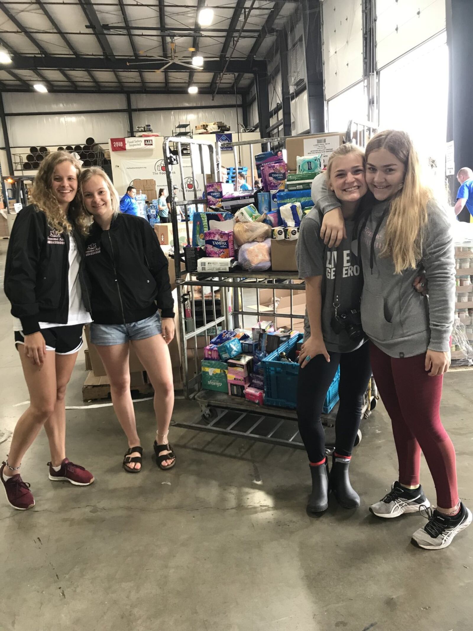 FemmeAid co-founders Ryann Mescher, Dana Clark, Zoe Waller and their friend Claire Parker deliver menstrual products to the Food Bank. CONTRIBUTED