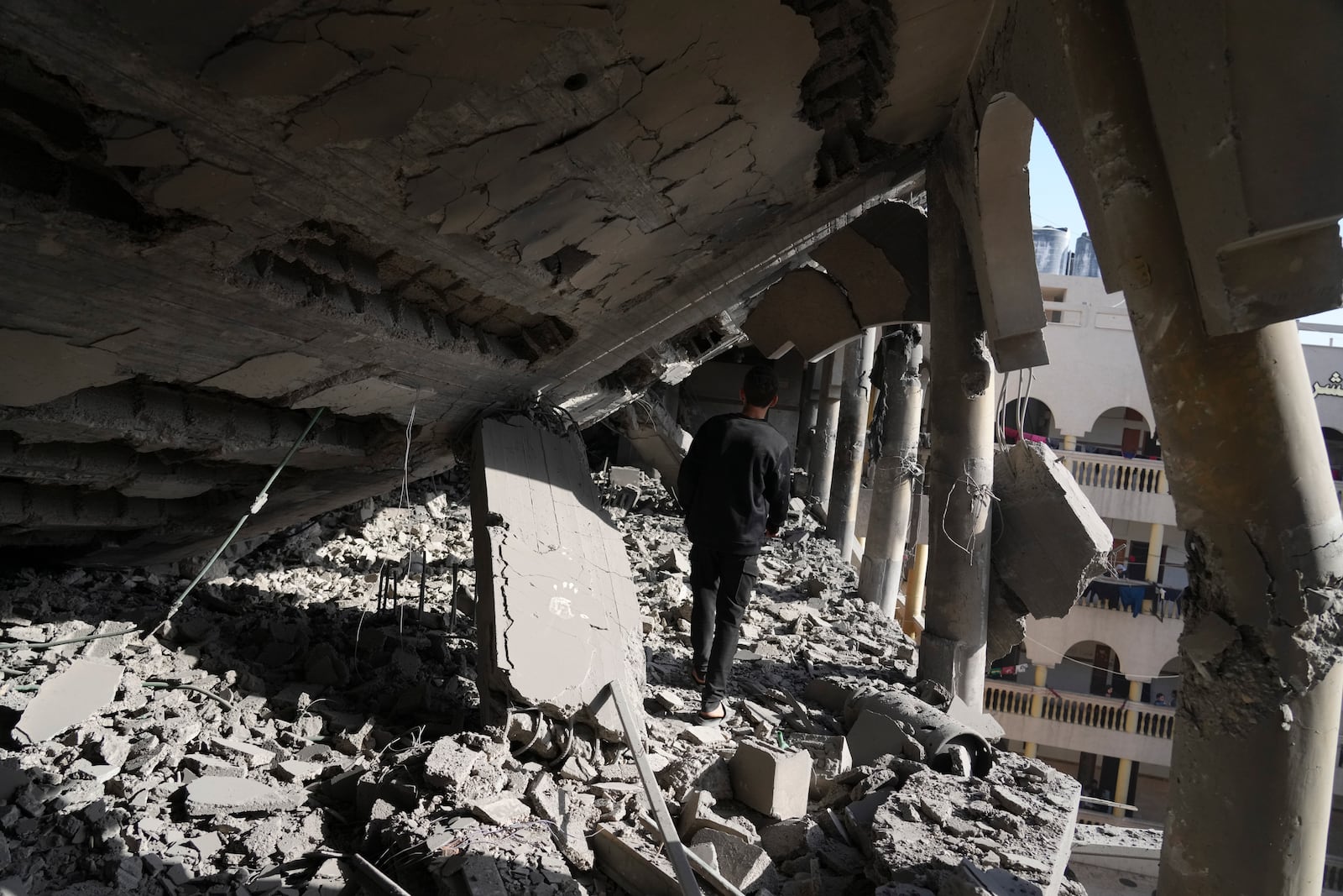 Palestinians inspect the damage at Al-Tabi'in School in central Gaza Strip following an Israeli airstrike, Tuesday, March 18, 2025. (AP Photo/Jehad Alshrafi)