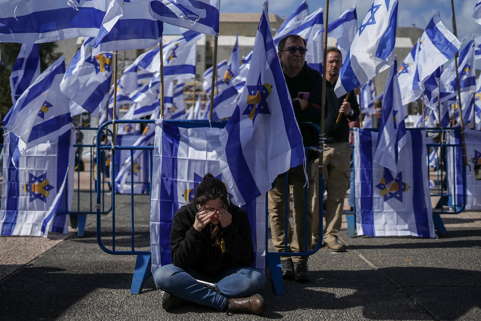 People react at the so-called 'Hostages Square' in Tel Aviv, Israel, Thursday, Feb. 20, 2025, as the bodies of four Israeli hostages, including a mother and her two children, are handed over by Hamas to the Red Cross in Gaza. (AP Photo/Oded Balilty)