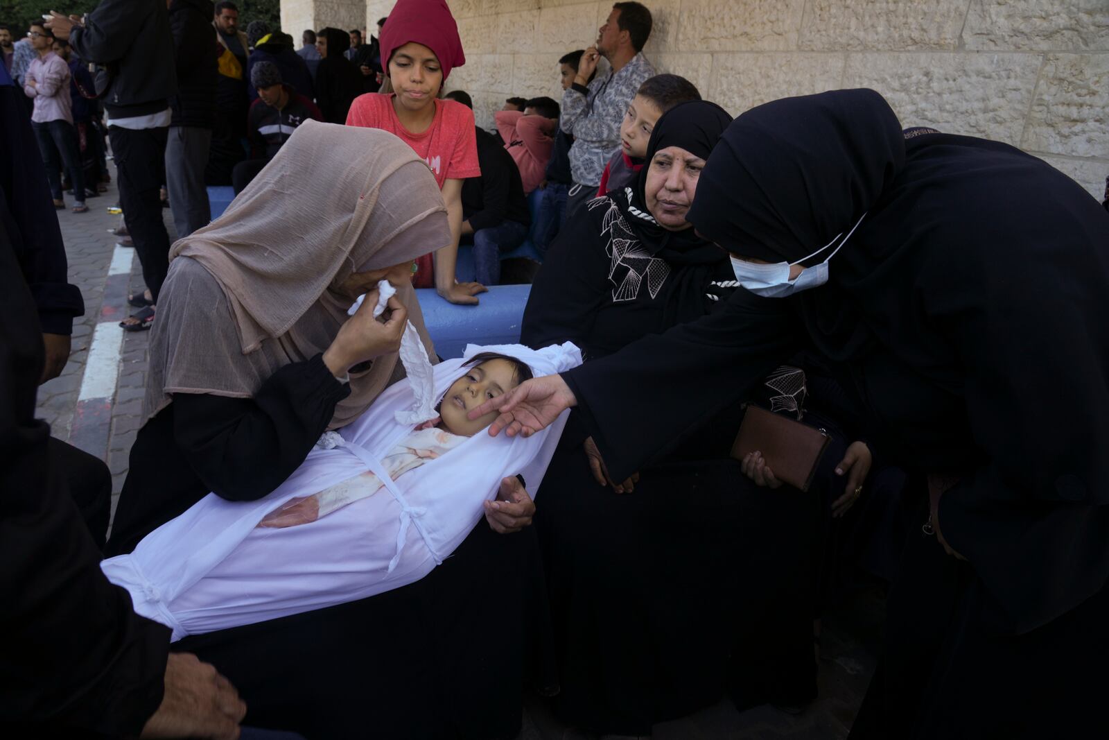 FILE - A mother cries for her daughter who was killed in the Israeli bombardment of the Gaza Strip al in Deir al Balah, Sunday, Dec. 3, 2023. (AP Photo/ Hatem Moussa, File)