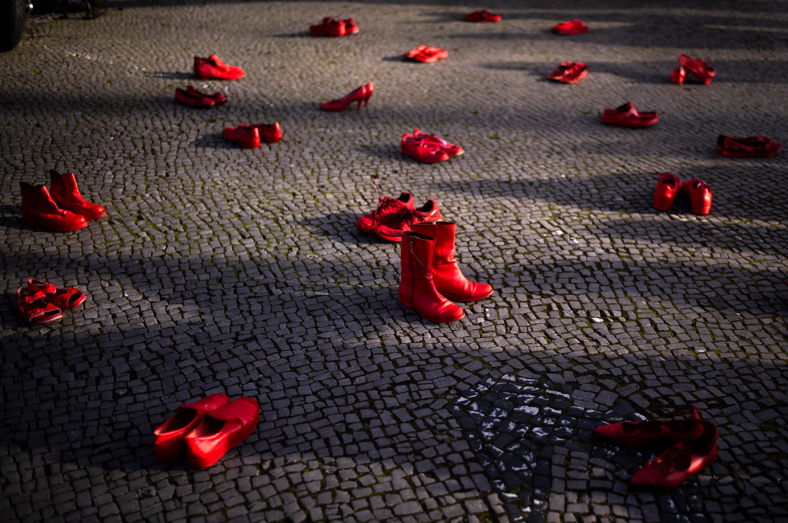 Red shoes placed on the ground as a symbol against the violence on women, during a rally marking the International Day for the Elimination of Violence Against Women, in Berlin, Germany, Monday, Nov. 25, 2024. (AP Photo/Markus Schreiber)