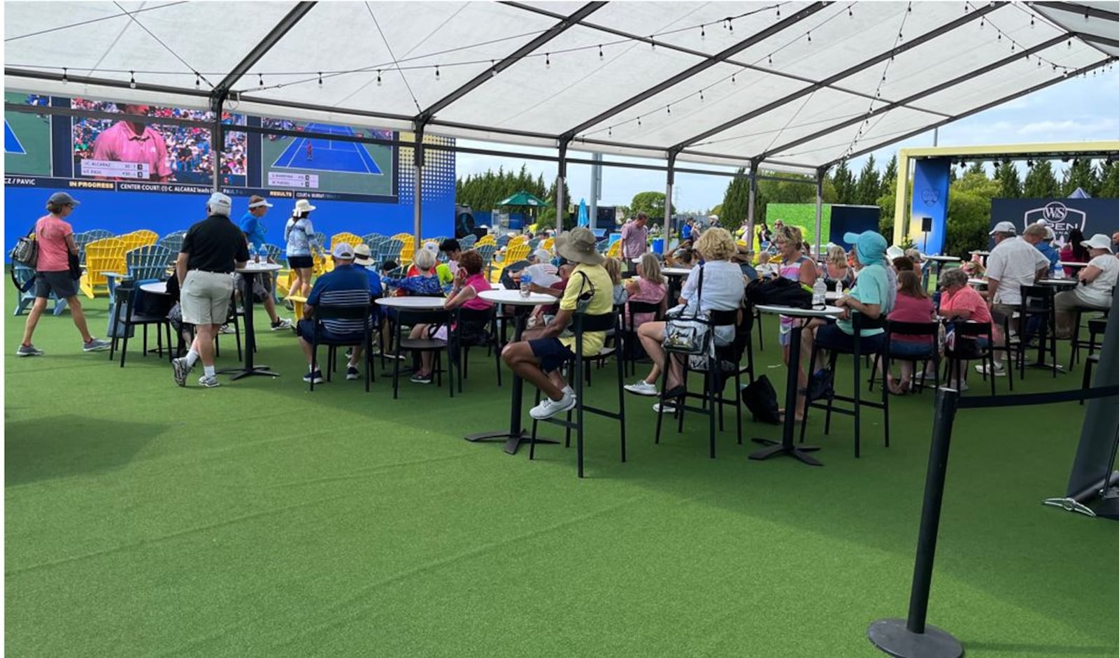 Fans enjoy beverages as they watch monitors of various matches under way at the Fan Zone at the Western & Southern Open in Mason.  ED RICHTER/STAFF