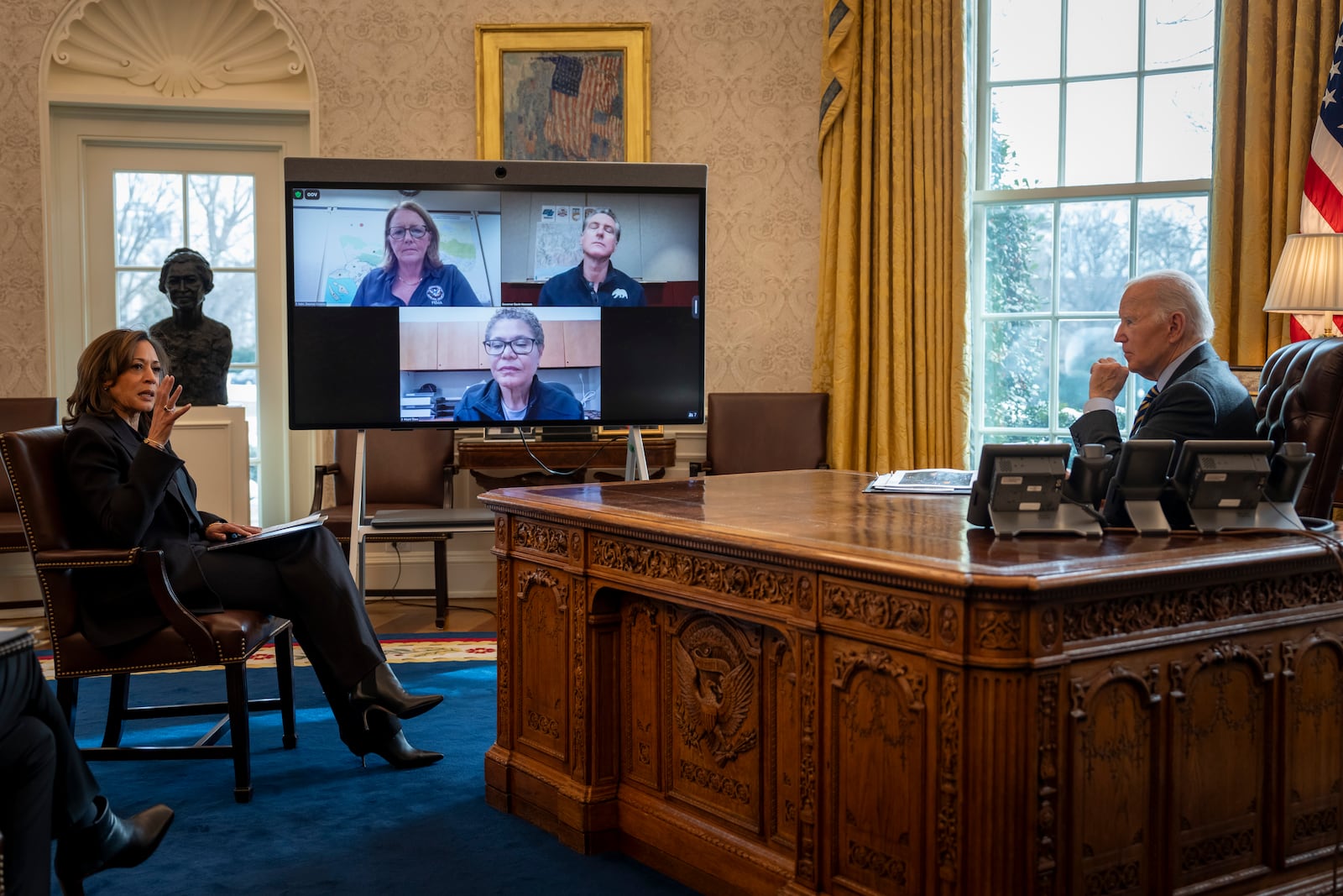 President Joe Biden, right, listens as Vice President Kamala Harris, left, speaks during a briefing from California Gov. Gavin Newsom, on screen top right, Federal Emergency Management Agency administrator Deanne Criswell, on screen top left, and Los Angeles Mayor Karen Bass, on screen at bottom, regarding the federal response to the spread of wildfires in the Los Angeles area, Friday, Jan. 10, 2025, in the Oval Office at the White House in Washington. (AP Photo/Ben Curtis)