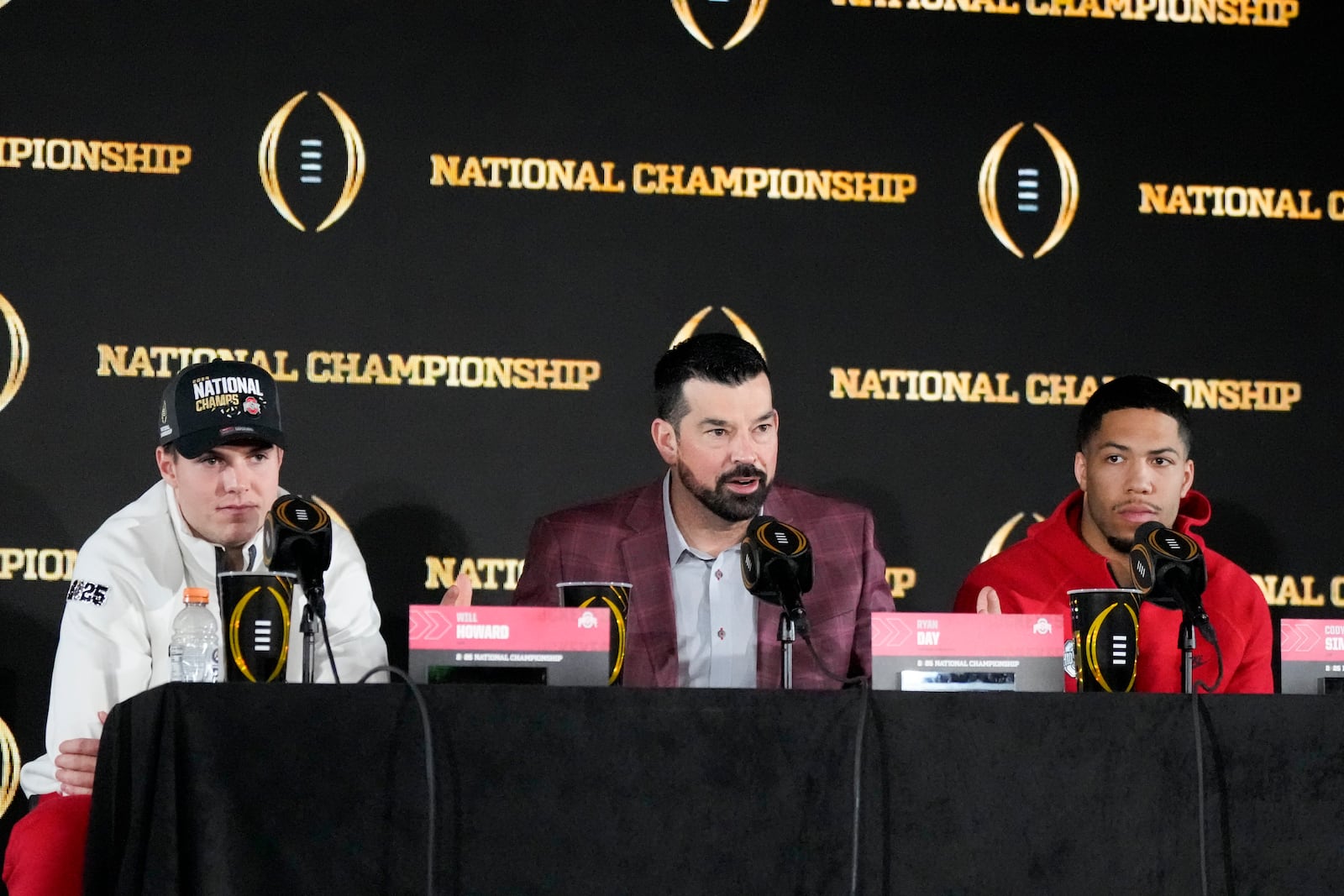 Ohio State quarterback Will Howard, head coach Ryan Day and linebacker Cody Simon participate in the winners news conference after the College Football Playoff national championship game against Notre Dame Tuesday, Jan. 21, 2025, in Atlanta. (AP Photo/Chris Carlson)