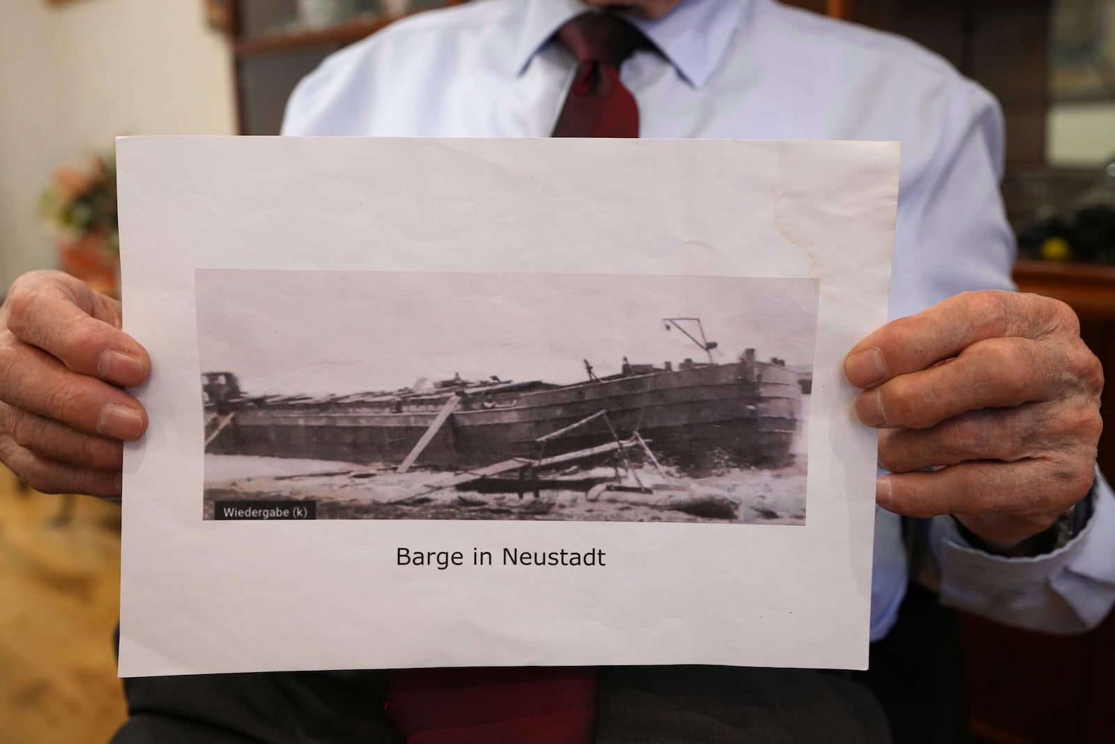 Manfred Goldberg, a Holocaust survivor displays a photograph of the barge in Neustadt, that he was transported on as he is interviewed in London, Wednesday, Jan. 22, 2025. (AP Photo/Kirsty Wigglesworth)